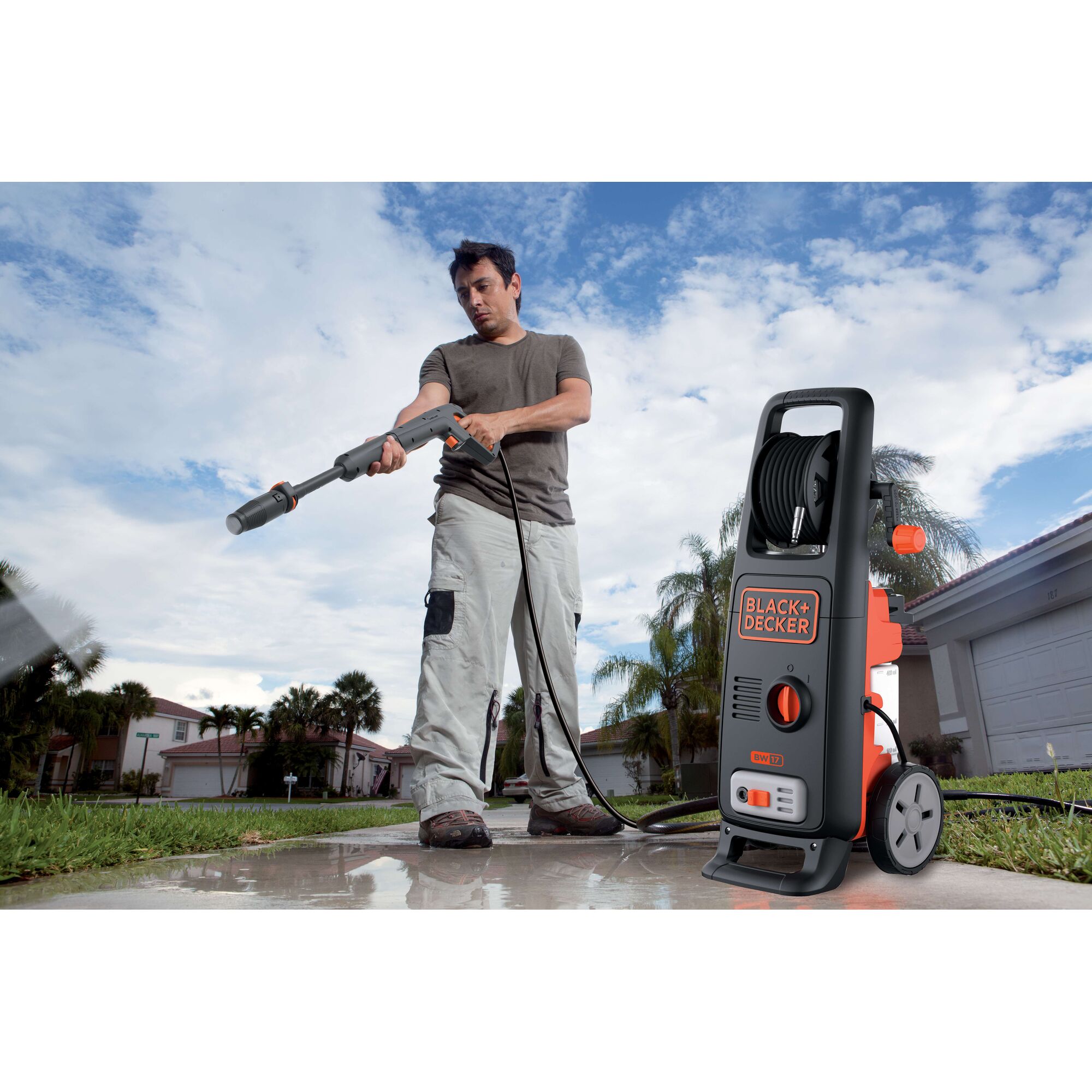 BLACK+DECKER BW17 pressure washer used outdoors on pavement, visible hose and control panel.