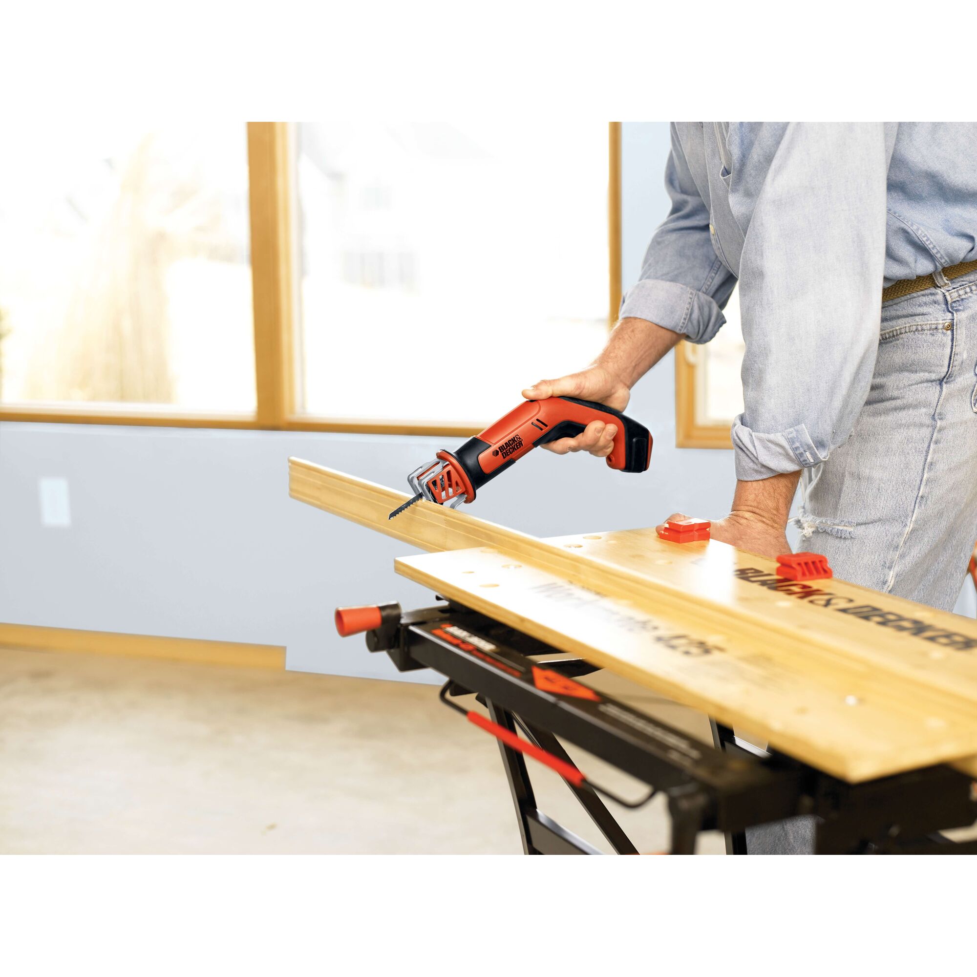 BLACKDECKER CHS6000 cordless reciprocating saw cutting wood on workbench indoors.