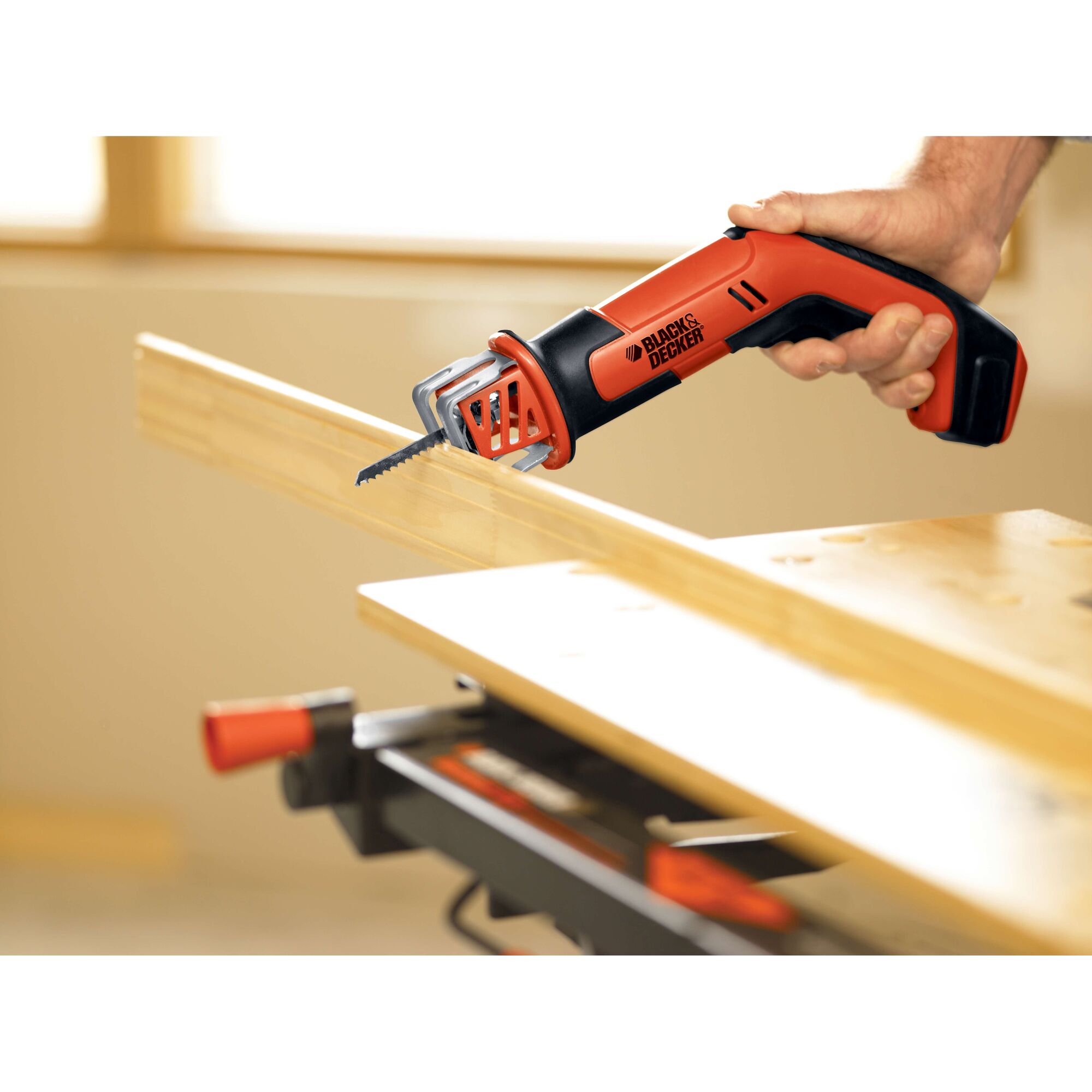 BLACKDECKER CHS6000 cordless reciprocating saw cutting wood plank, close-up in workshop.
