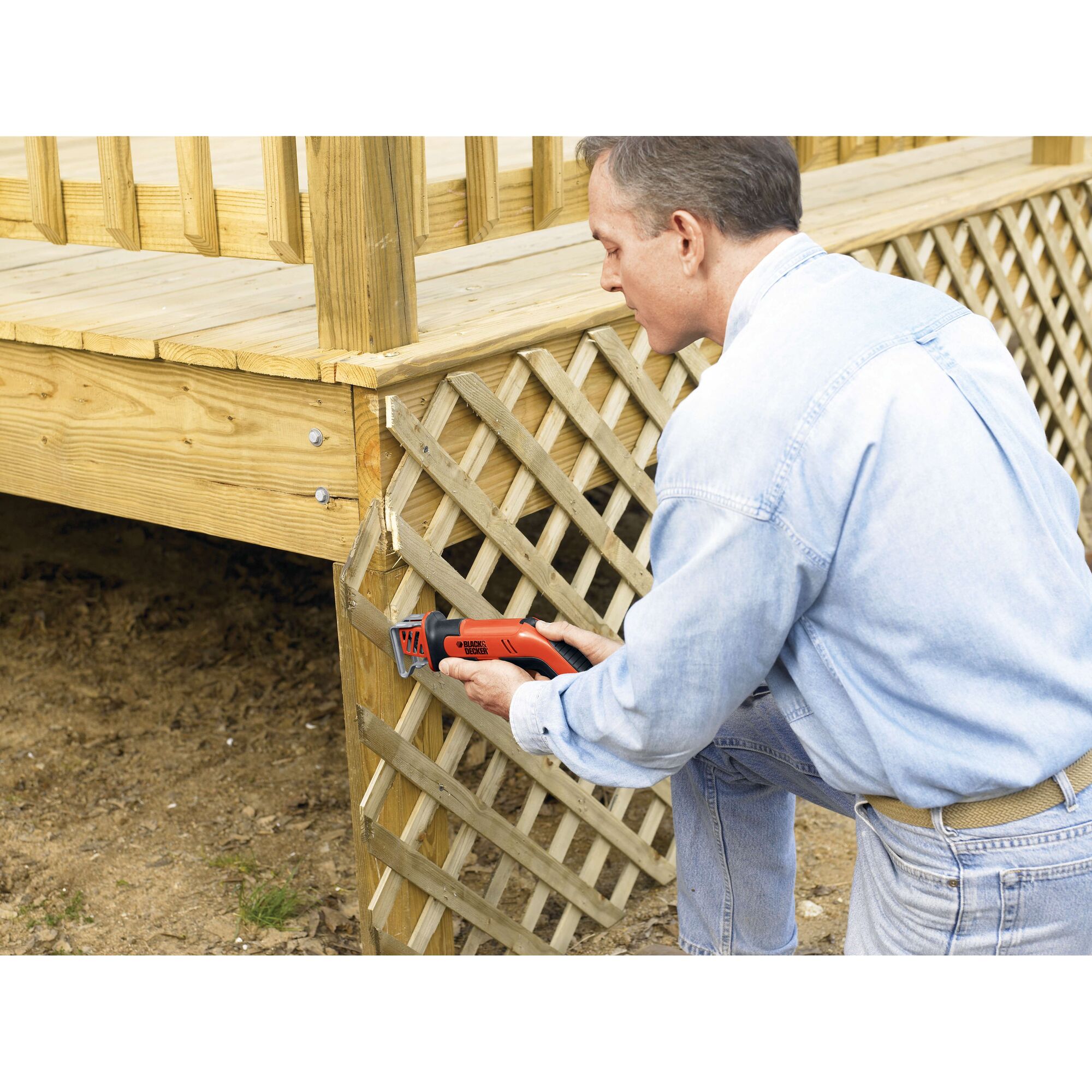 BLACKDECKER CHS6000 reciprocating saw used to cut wooden lattice on outdoor deck.
