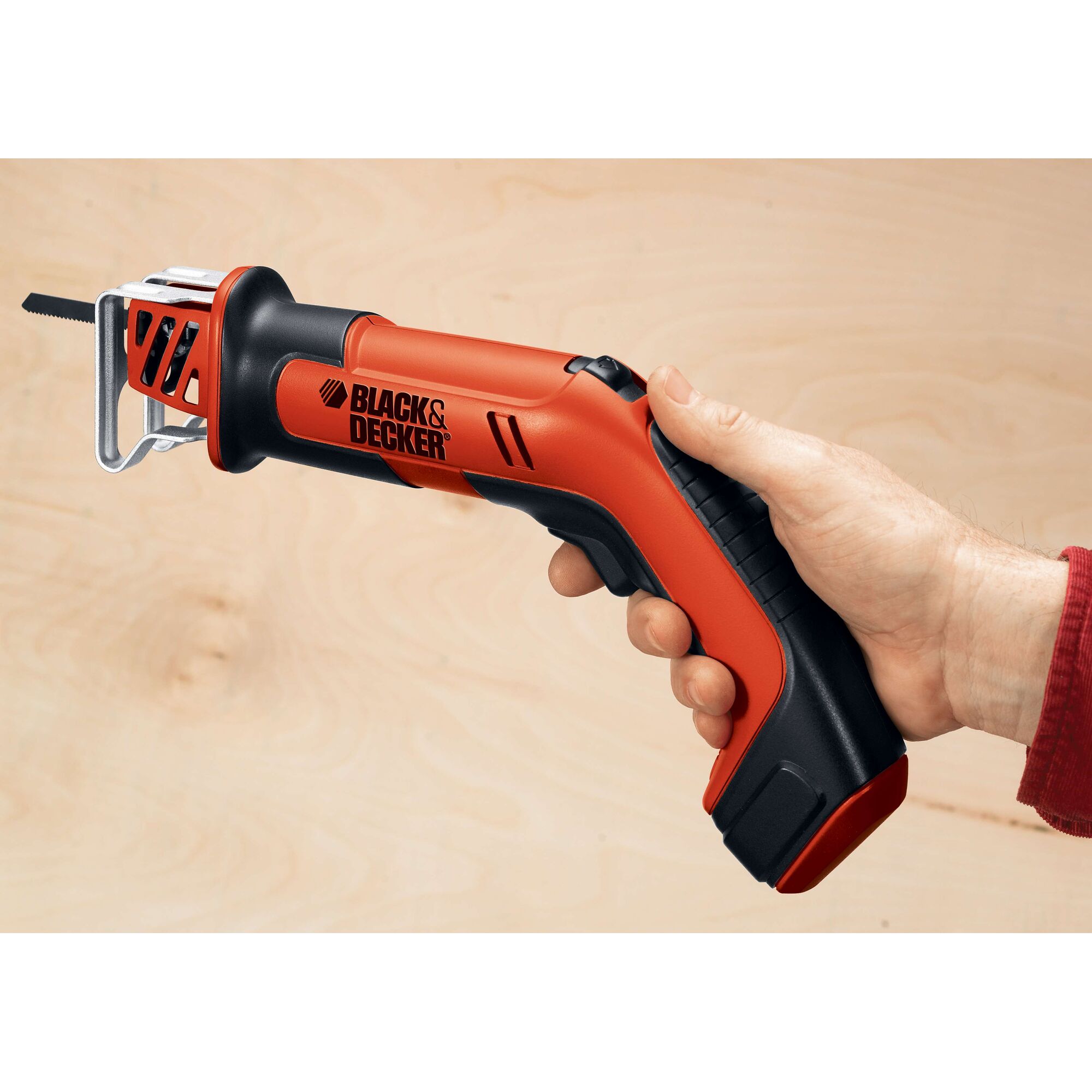 BLACK+DECKER CHS6000 cordless hand saw held by a person against light wood background.