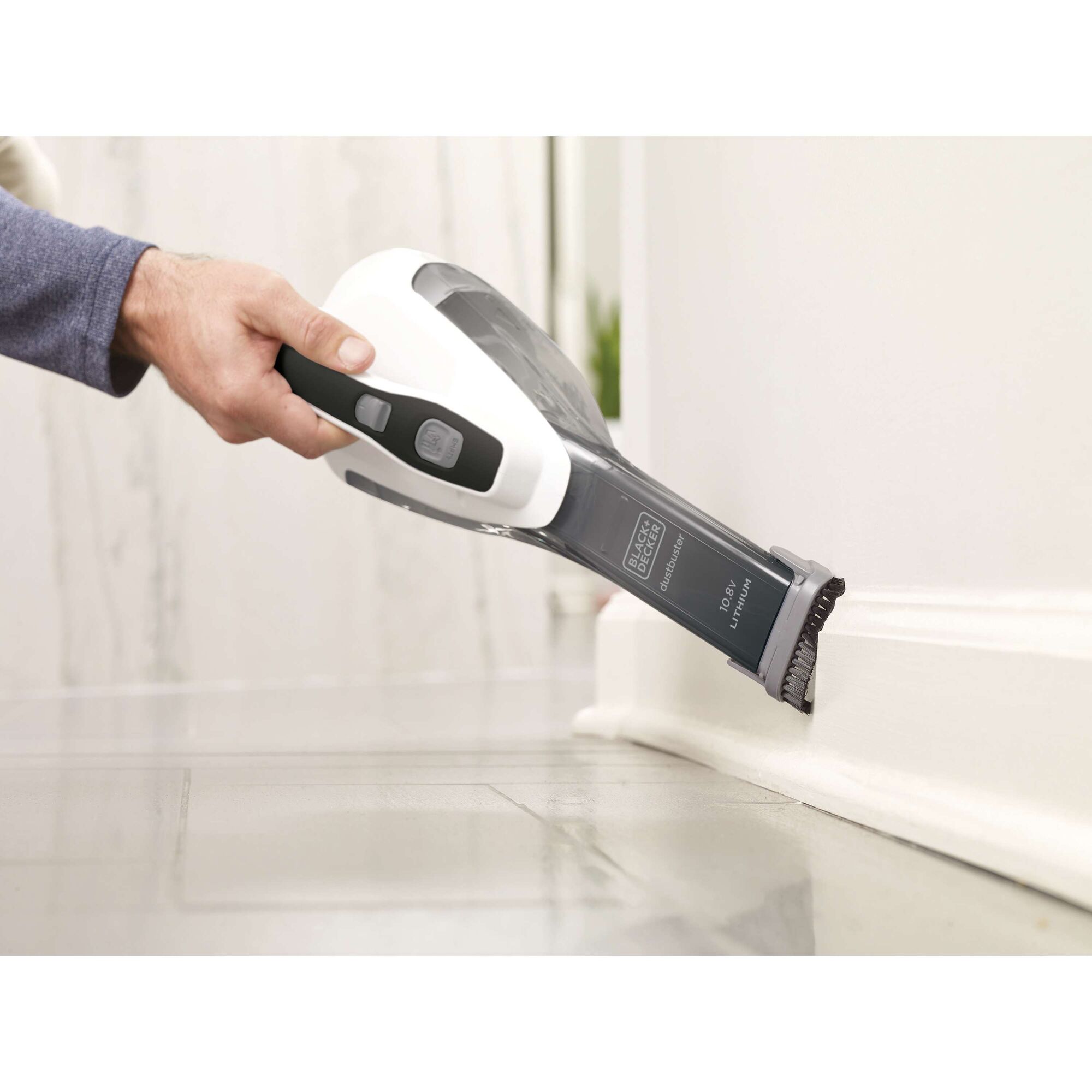BLACKDECKER DVA315JF handheld vacuum cleaning tile floor corner, white and black design.