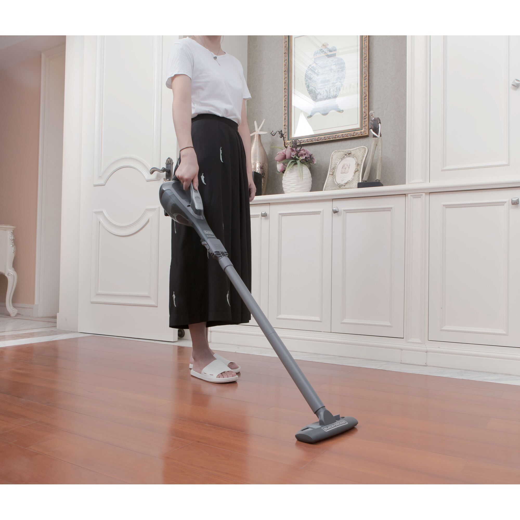 BLACKDECKER DVA320BF handheld vacuum cleaner being used on wooden floor in home setting