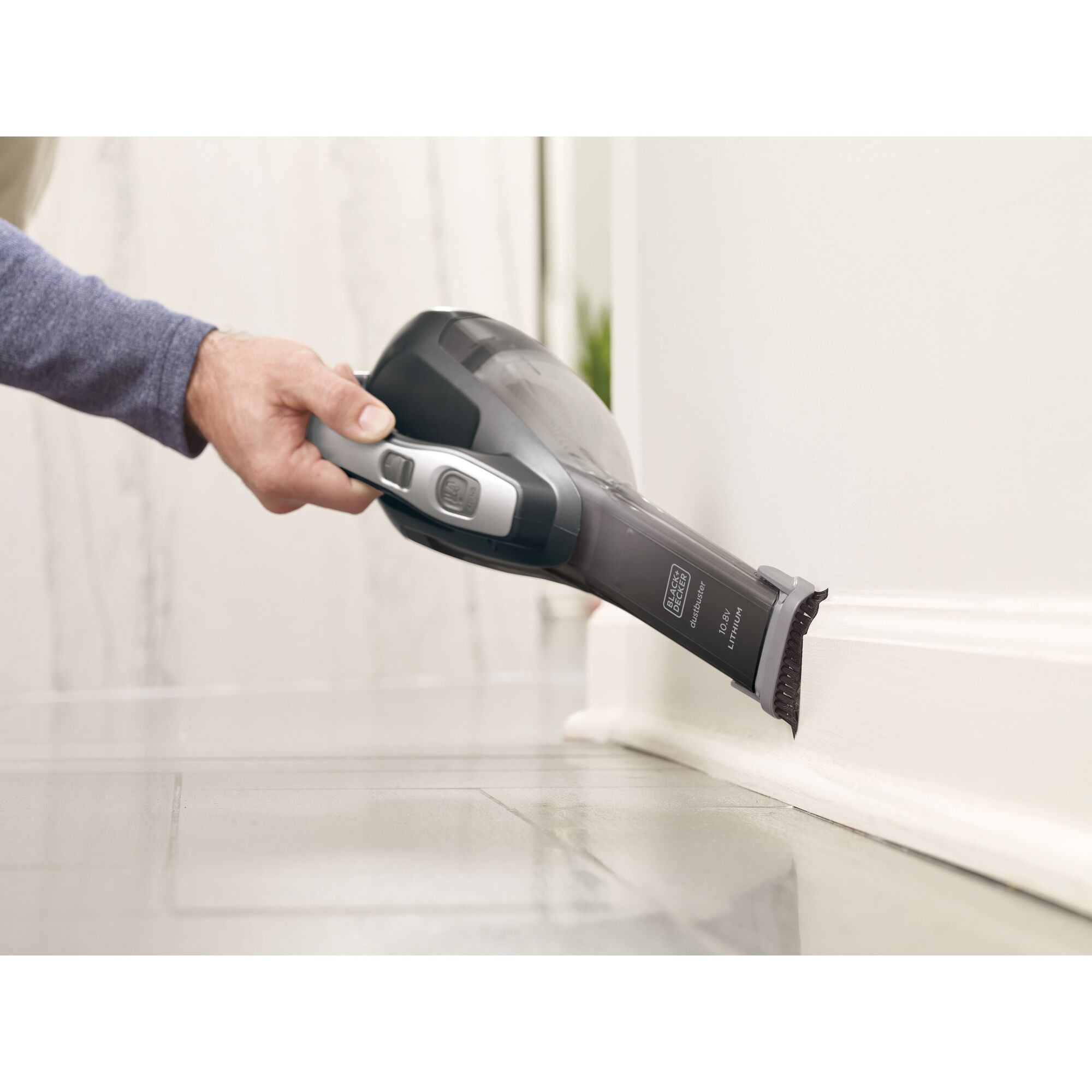 BLACKDECKER DVA320BF handheld vacuum cleaner with brush cleaning floor edge, side angle