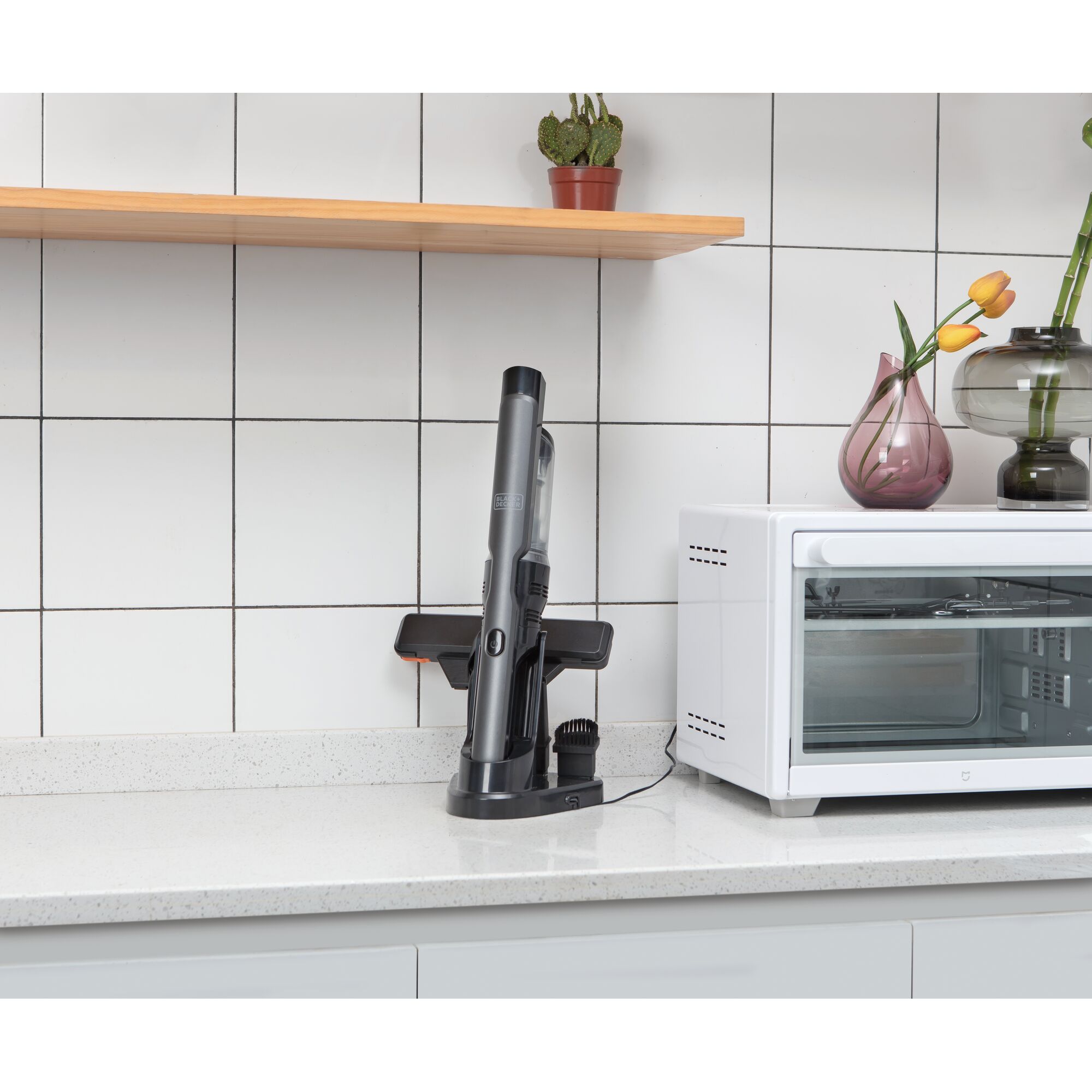 BLACKDECKER DVC320B01 handheld vacuum on charging base, kitchen counter, side angle.