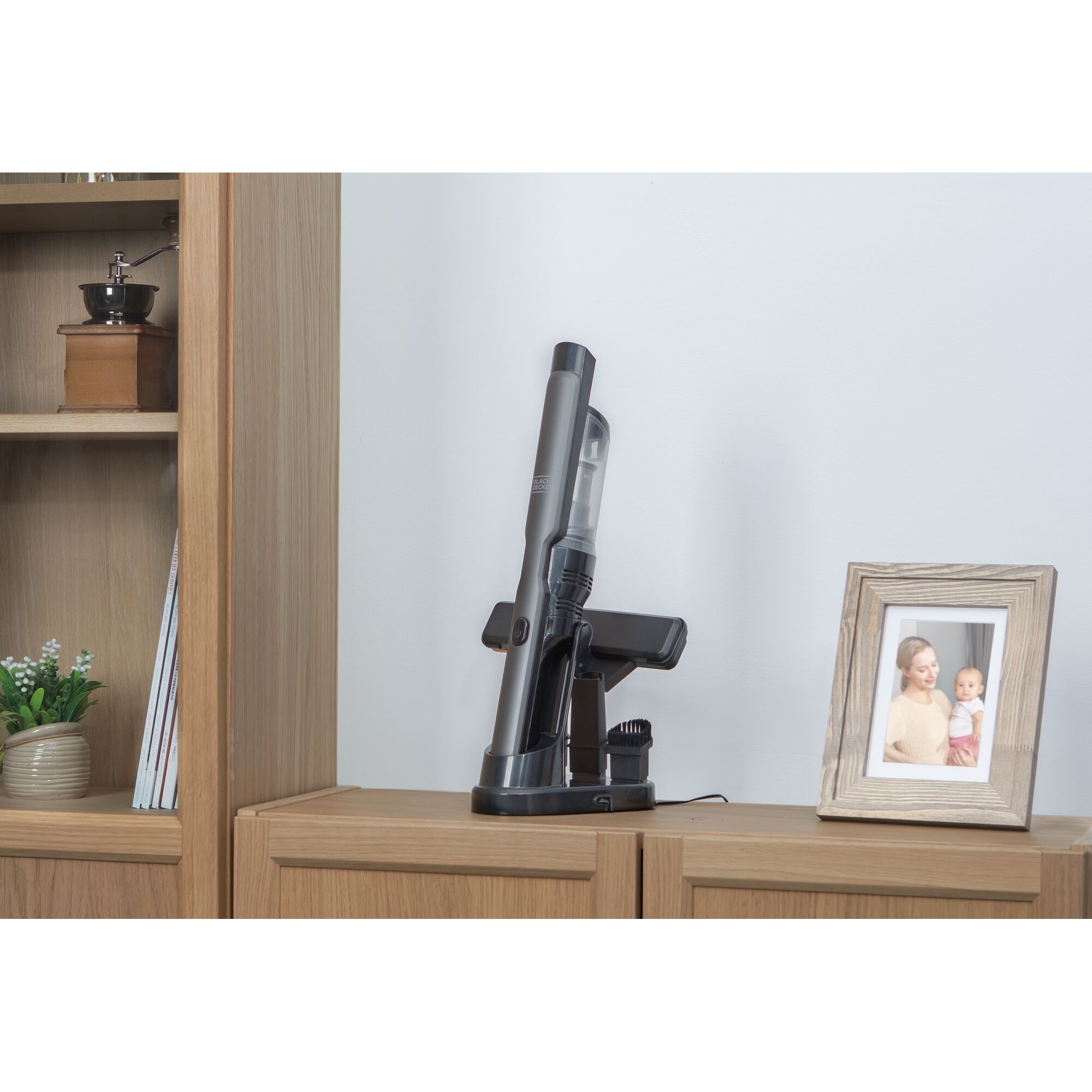 BLACKDECKER DVC320B01 cordless handheld vacuum displayed upright on a wooden cabinet, photography side view.