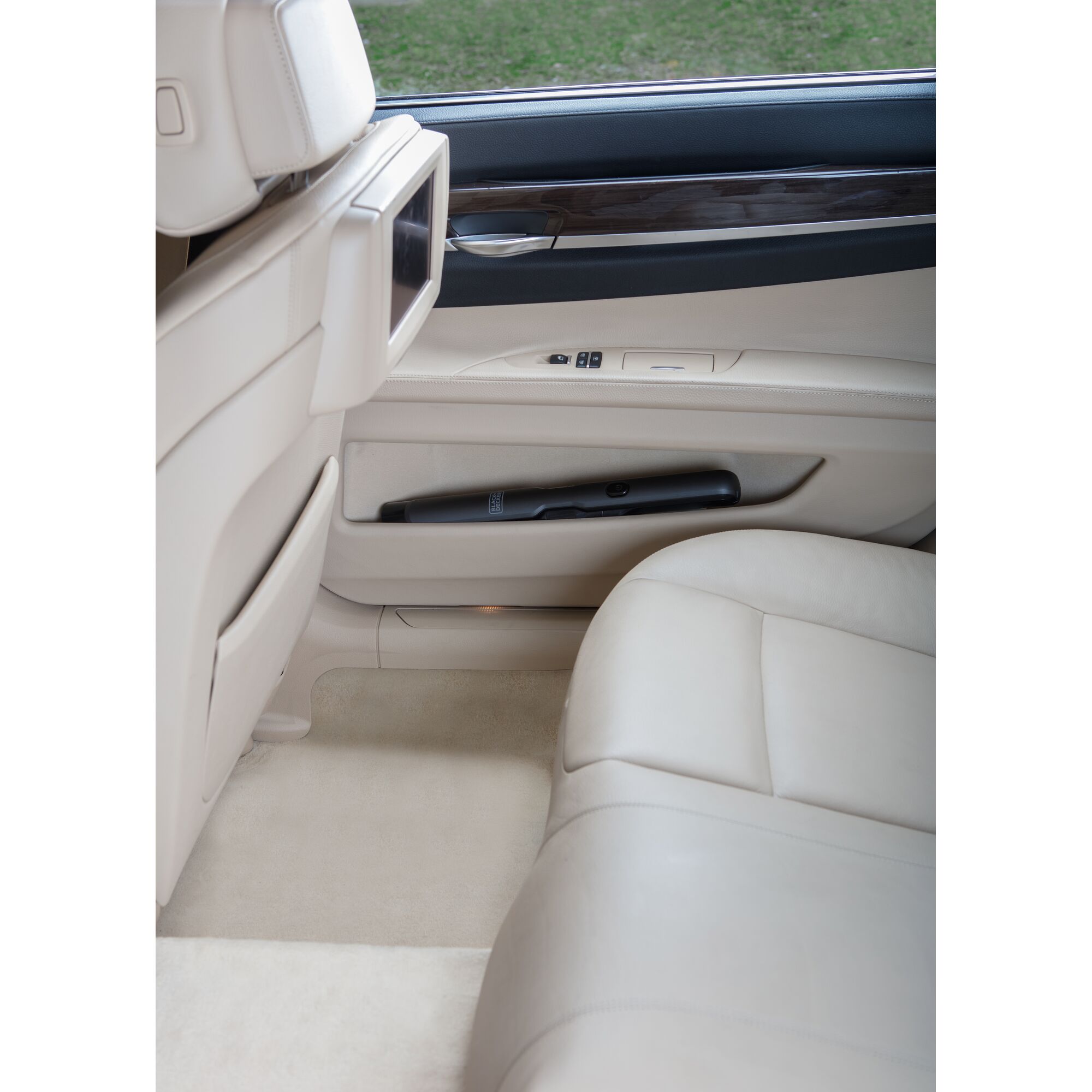 BLACKDECKER DVC320B01 handheld vacuum in beige car door pocket, rear seat angle.