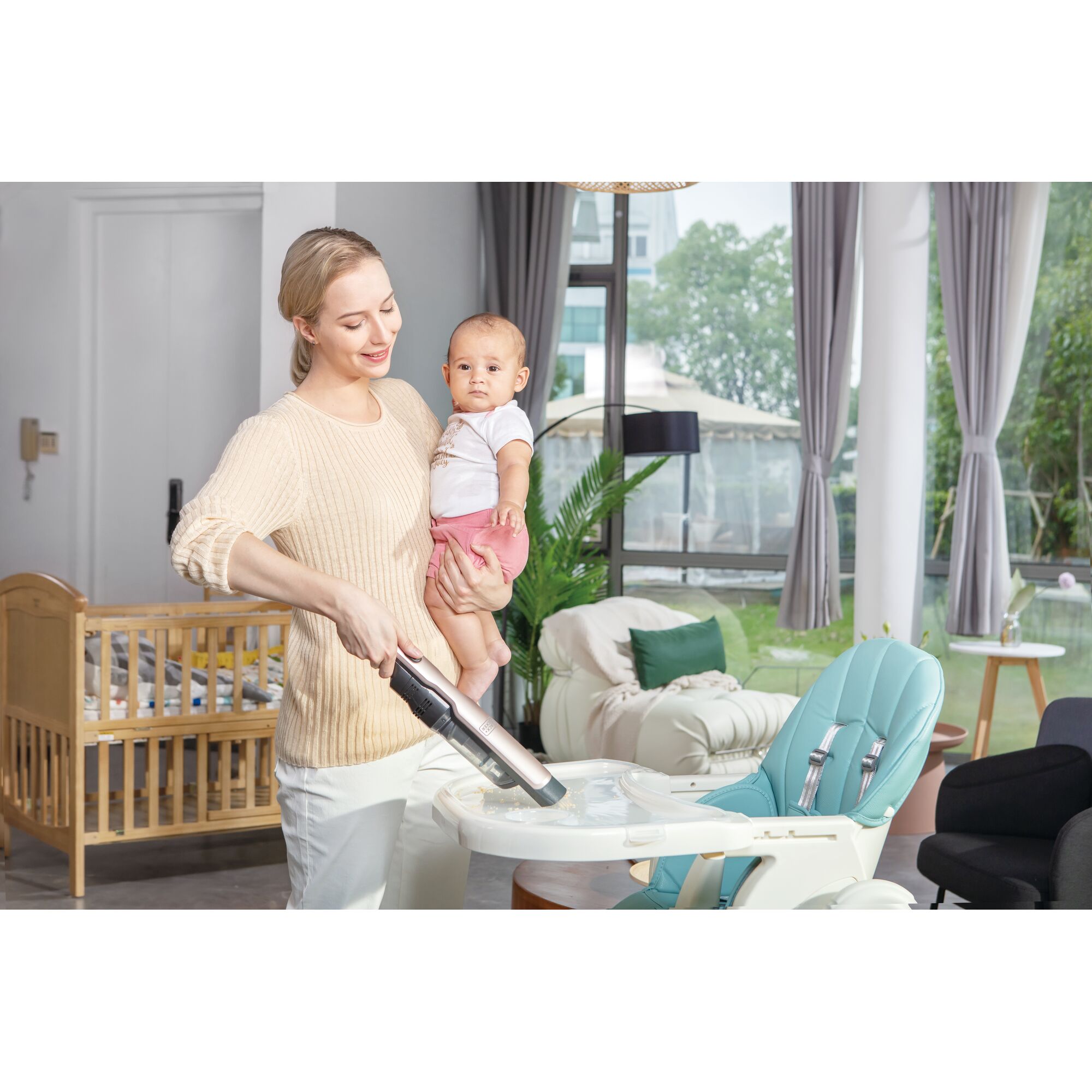 BLACKDECKER DVC320B24 handheld vacuum cleaning baby high chair in modern living room.