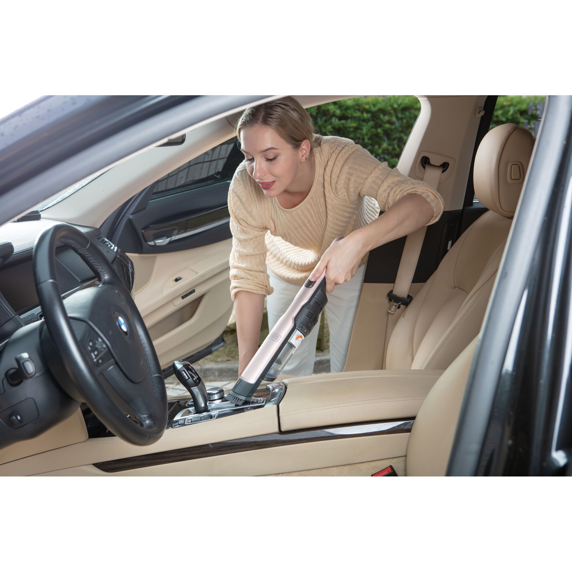 BLACKDECKER DVC320B24 handheld vacuum cleaner used for cleaning beige car interior.