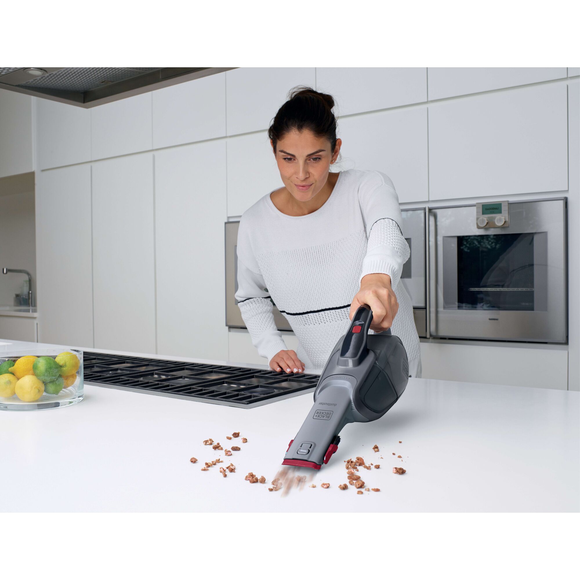BLACKDECKER DVJ315B handheld vacuum cleaning crumbs from a white kitchen counter.