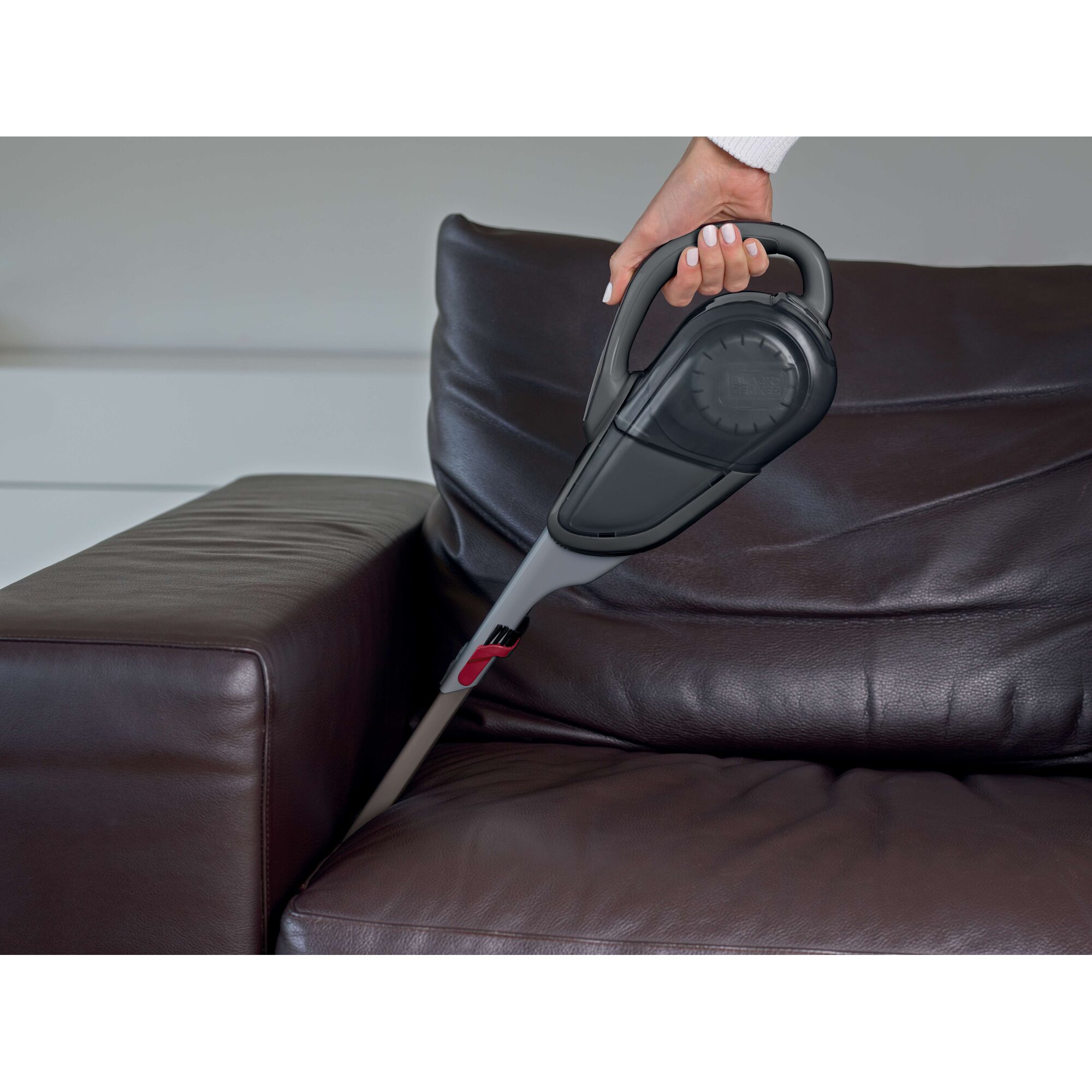 BLACKDECKER DVJ315B handheld vacuum cleaning brown leather sofa crevice.