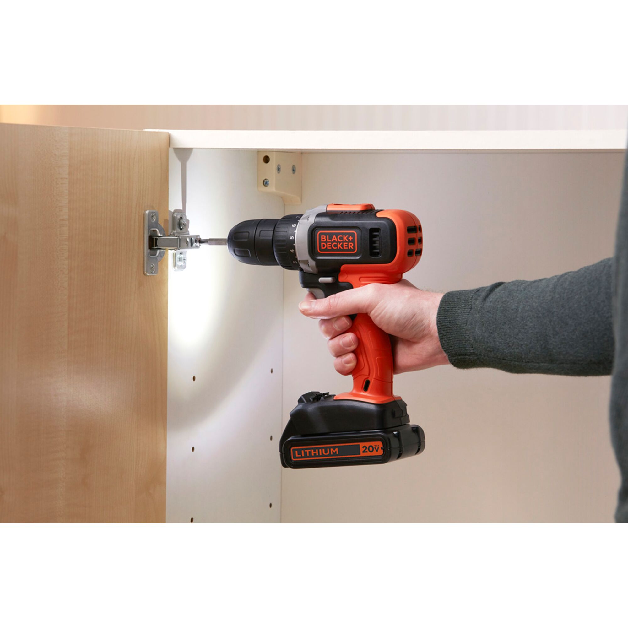 Photo of BLACK+DECKER EBCD703K cordless drill being used to install a hinge on a cabinet.