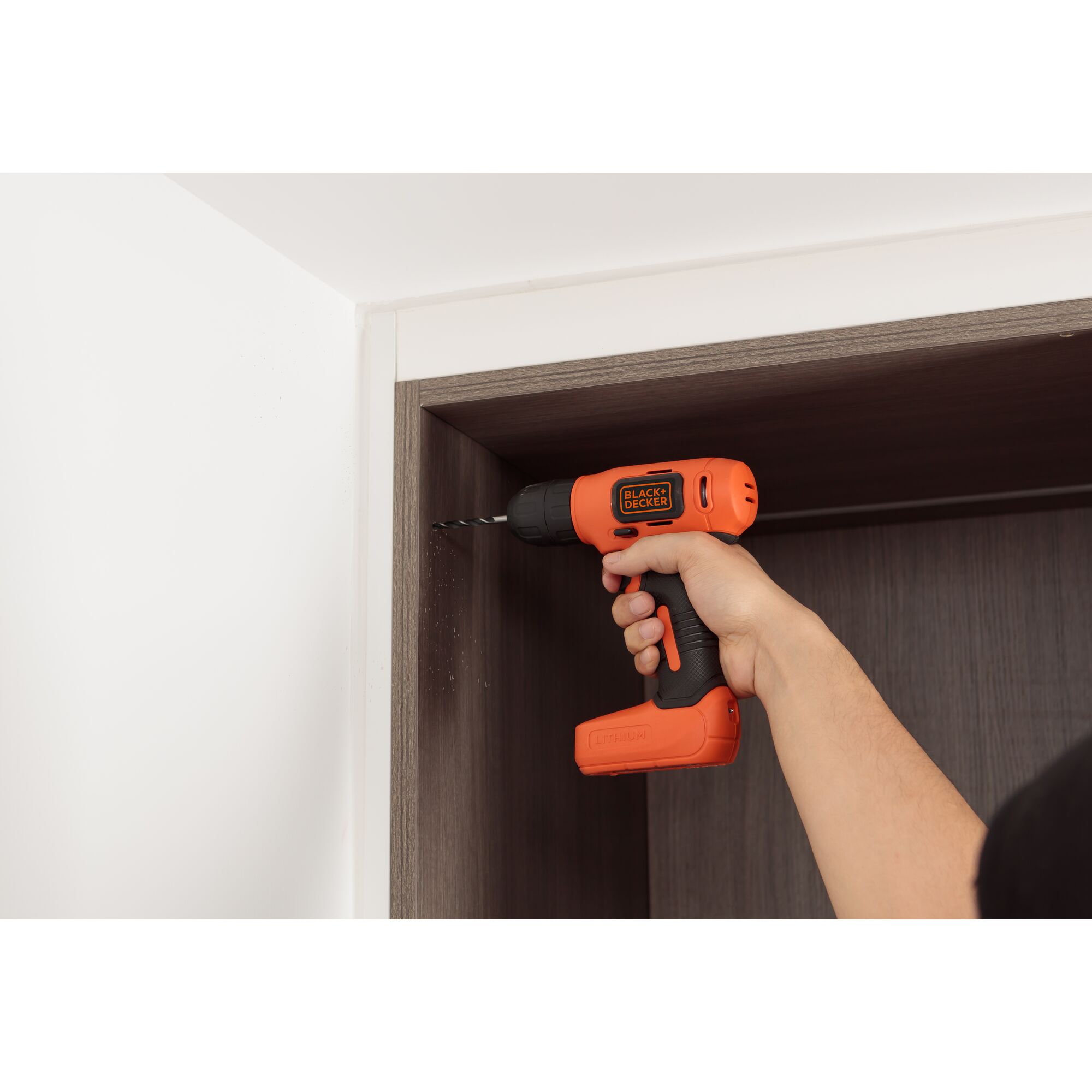 Photo of BLACKDECKER EBDCD8HDPK cordless drill in use on wooden cabinet interior.