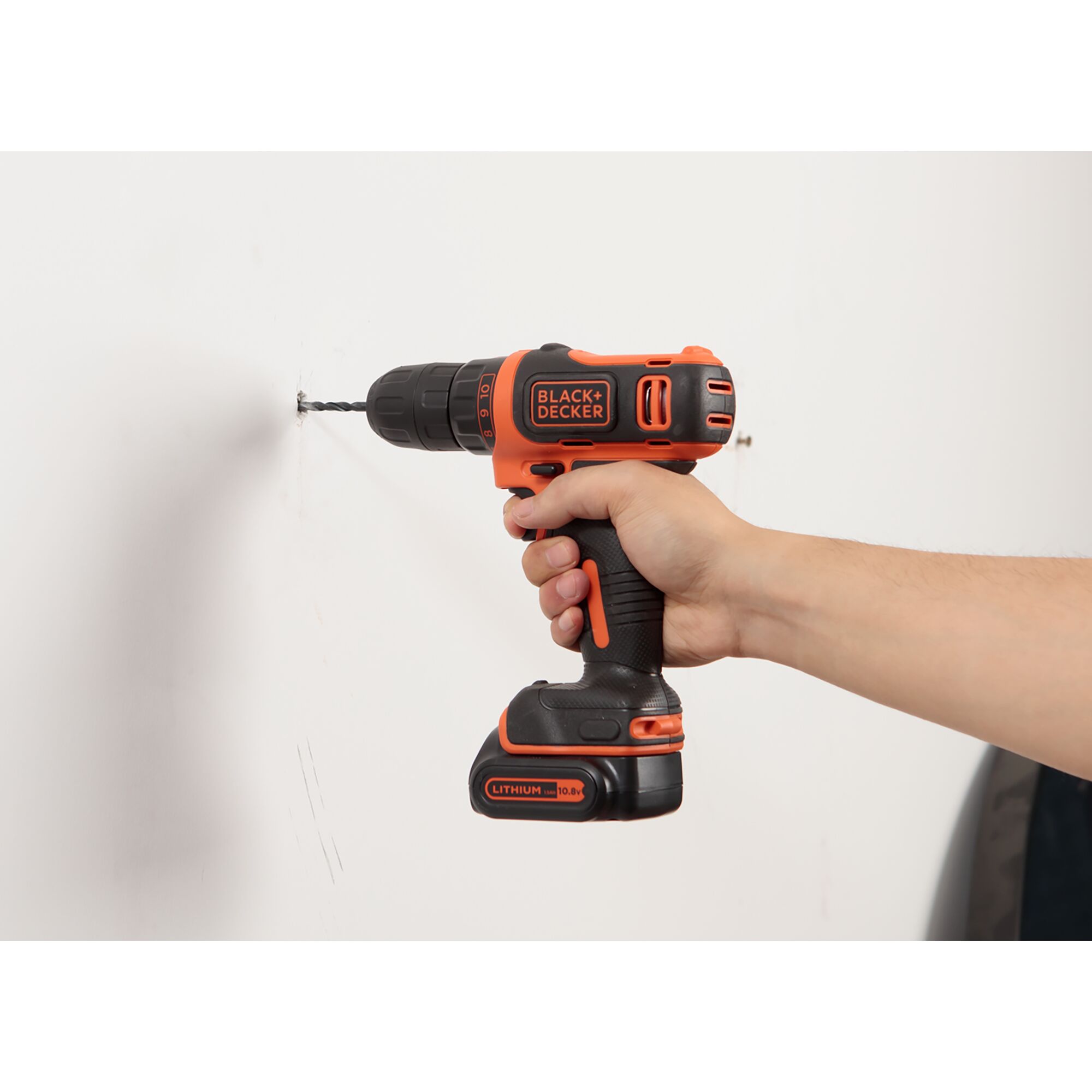BLACKDECKER EBDCDD12HS cordless drill with lithium battery, side view, drilling into white wall.
