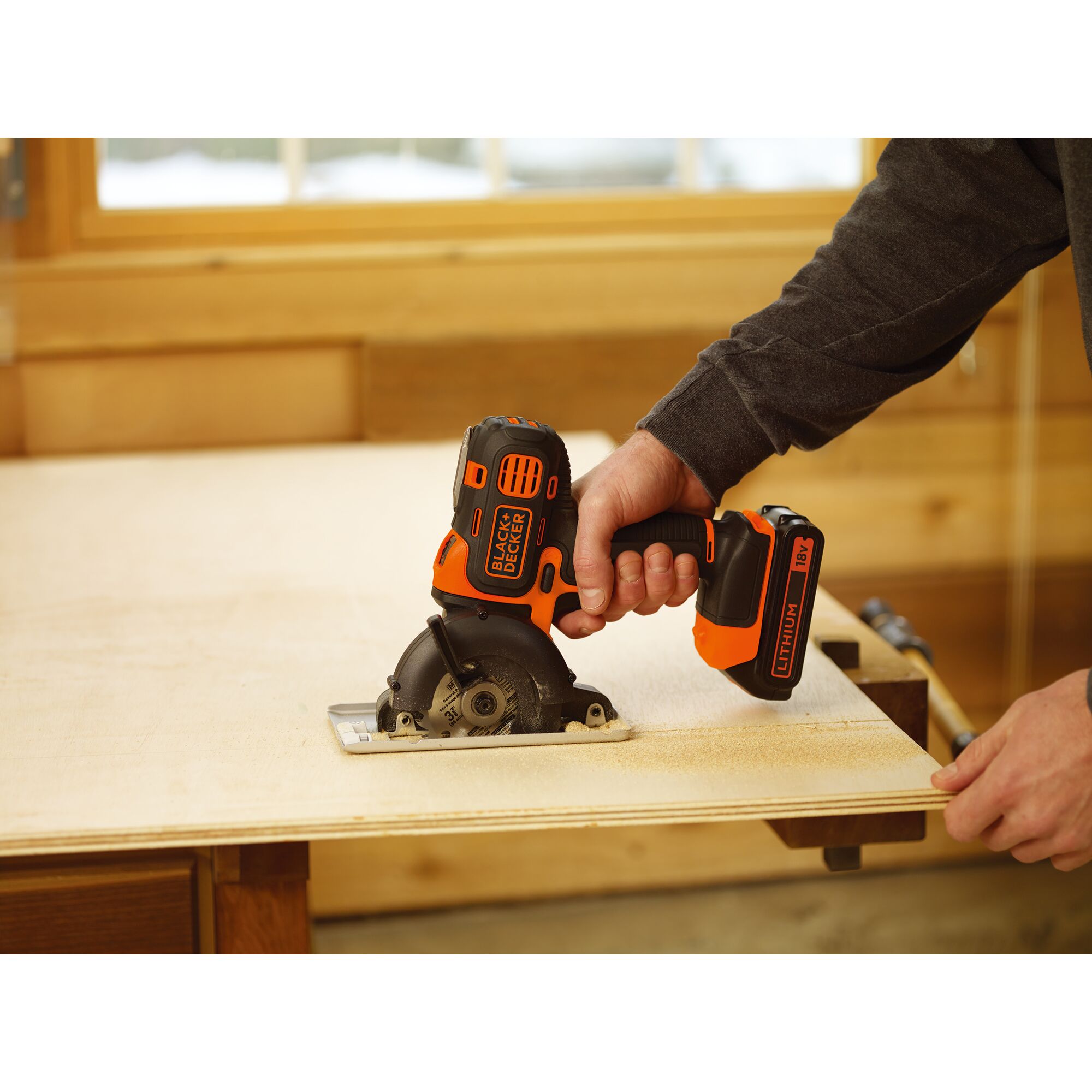 BLACKDECKER ECH183 cordless circular saw in use cutting plywood on workbench.