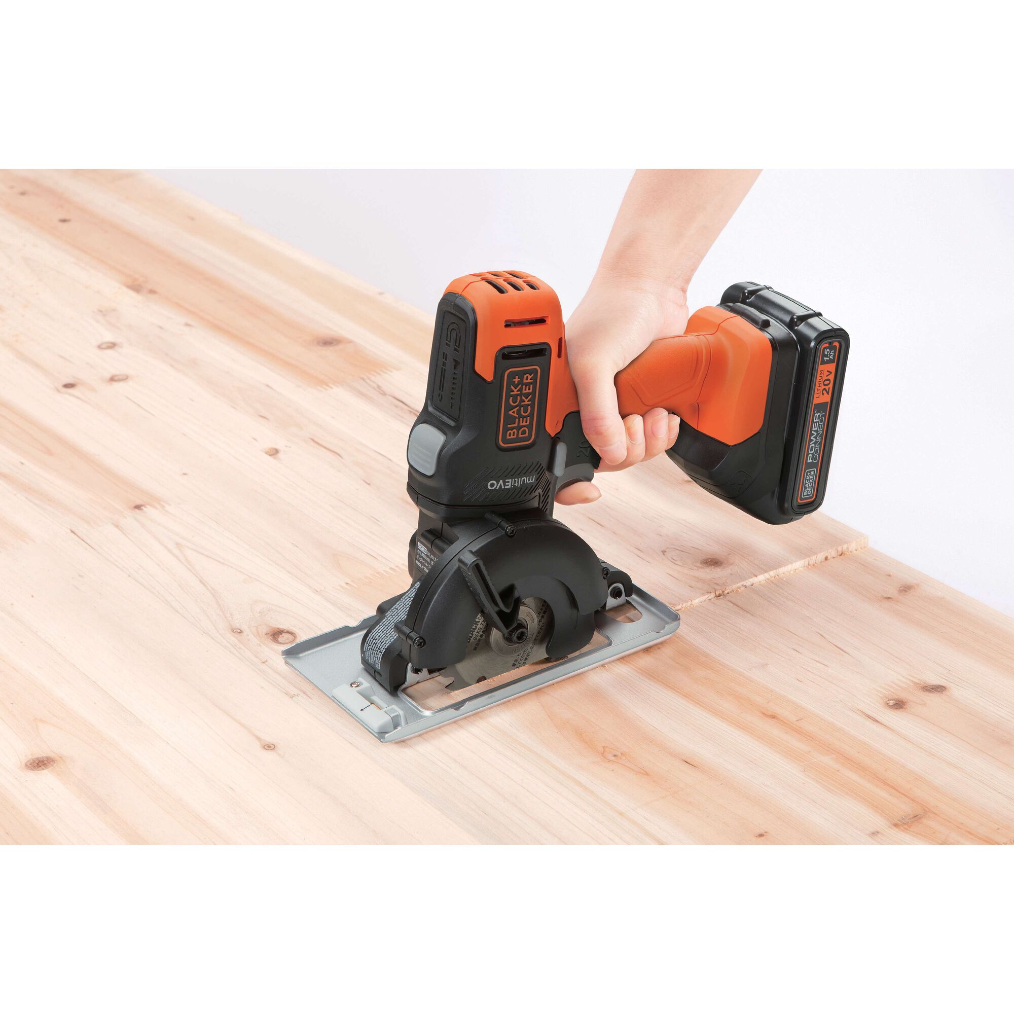 BLACKDECKER ECH183 cordless circular saw cutting wood, side angle, orange and black tool.