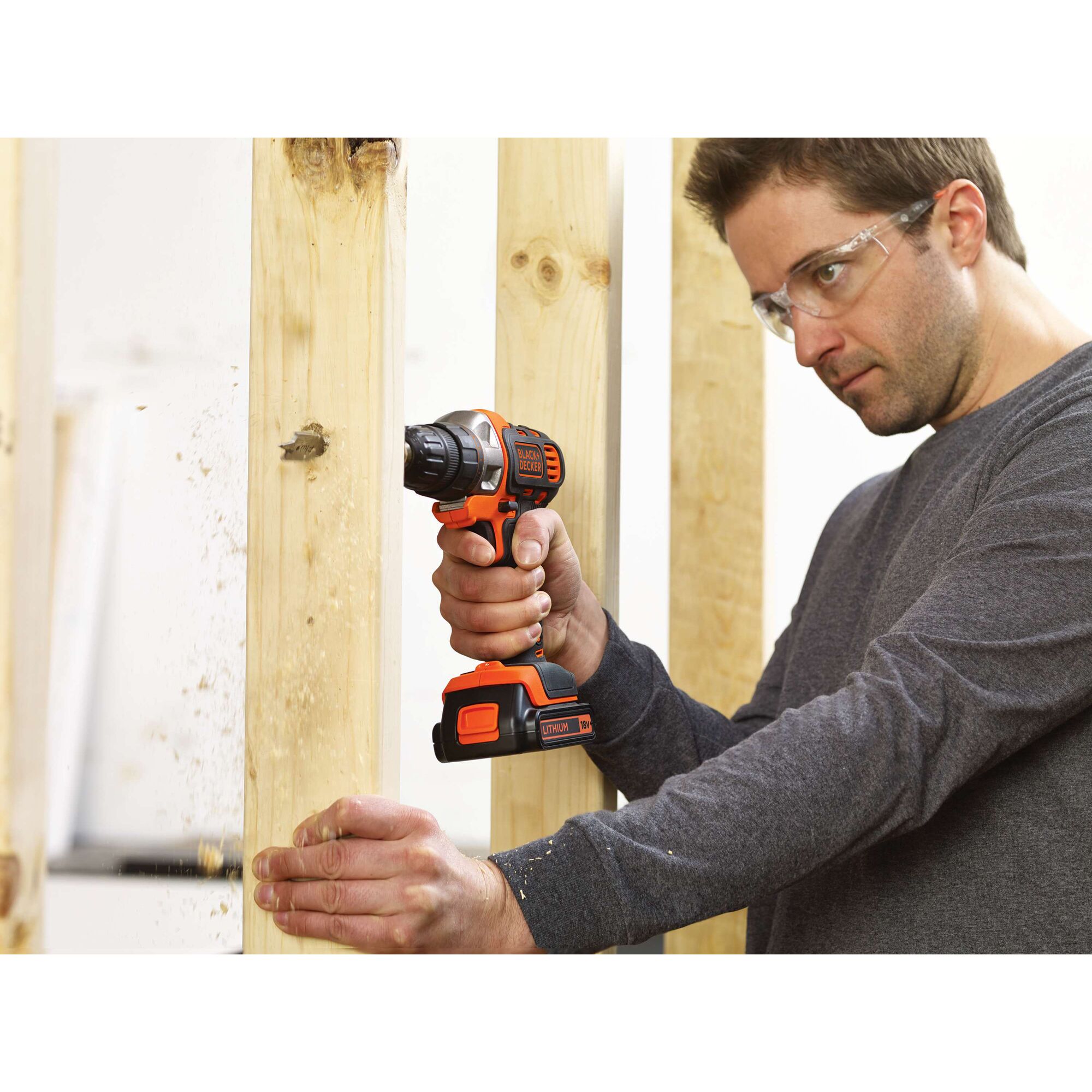 BLACKDECKER EDD183 cordless drill being used on wooden beams, close-up hand view.