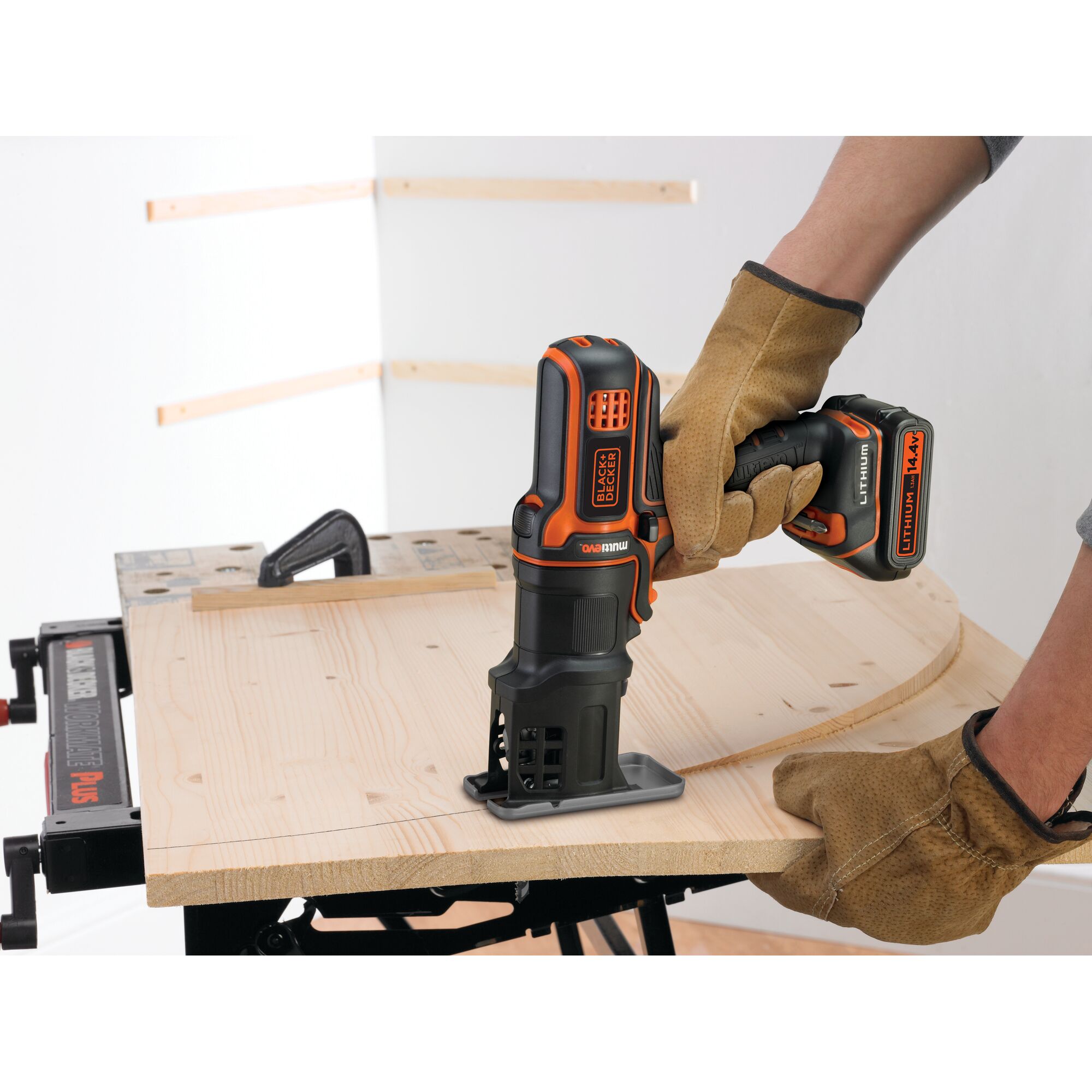 BLACKDECKER EJS183 cordless jigsaw cutting wood, held by gloved hands, indoor workshop setting.