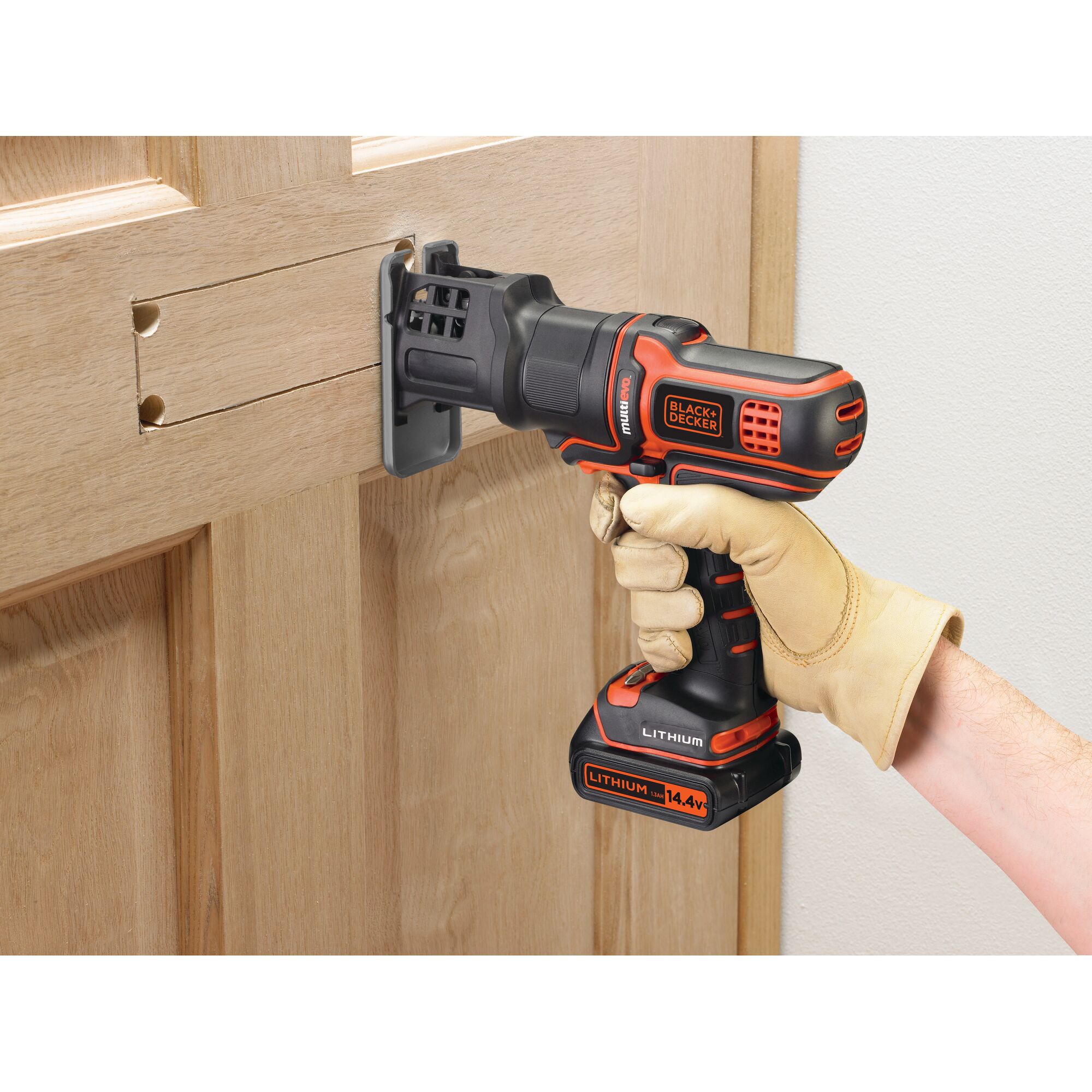 BLACKDECKER EJS183 jigsaw cutting wood door, close-up view, orange and black design.
