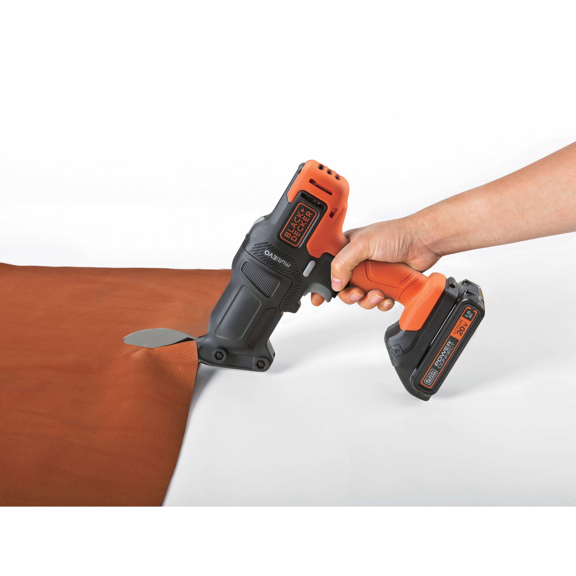BLACKDECKER EMS183 cordless electric shear cutting brown fabric, side angle, black and orange design.