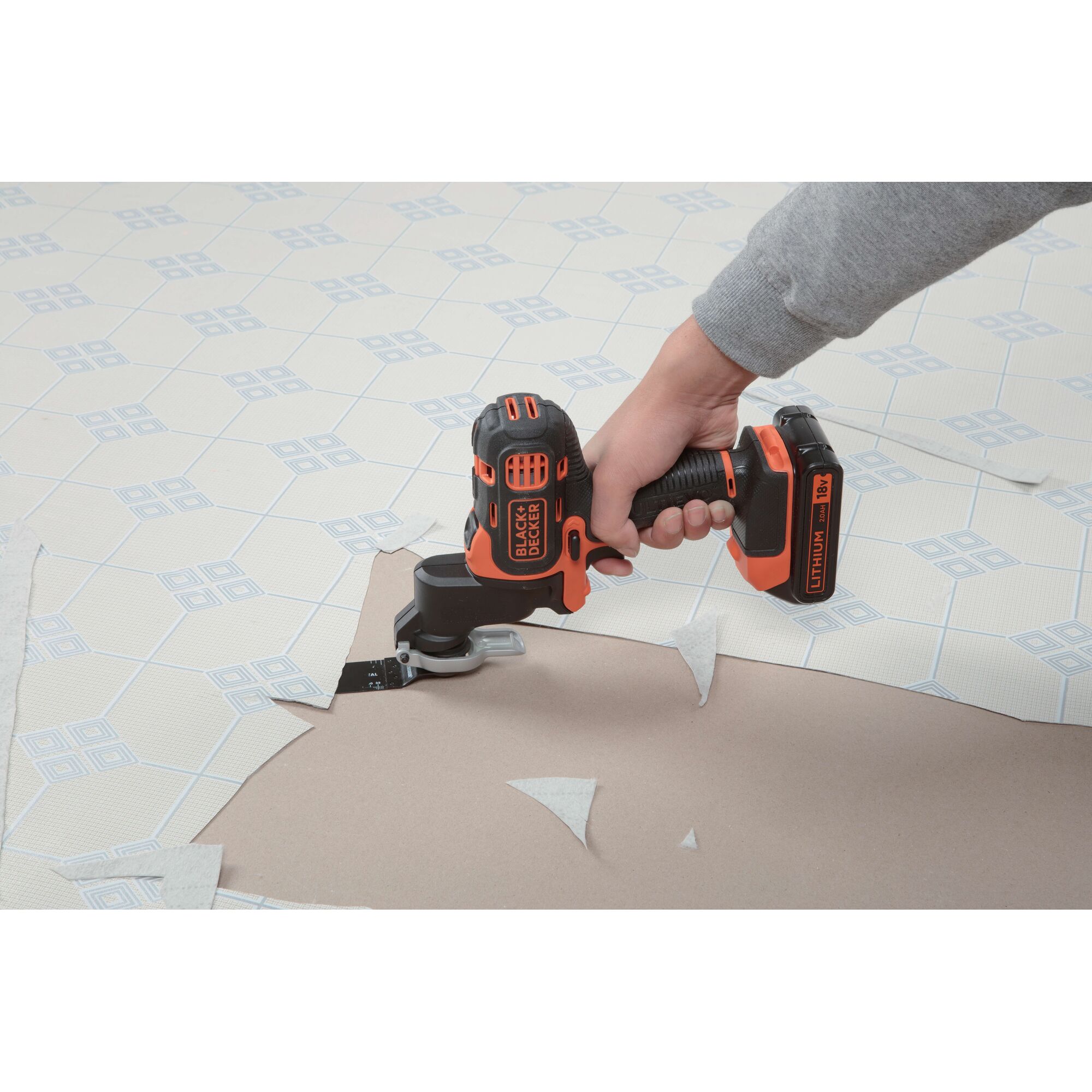 Photo of BLACKDECKER EOH183 cordless multi-tool cutting floor tiles on patterned surface.