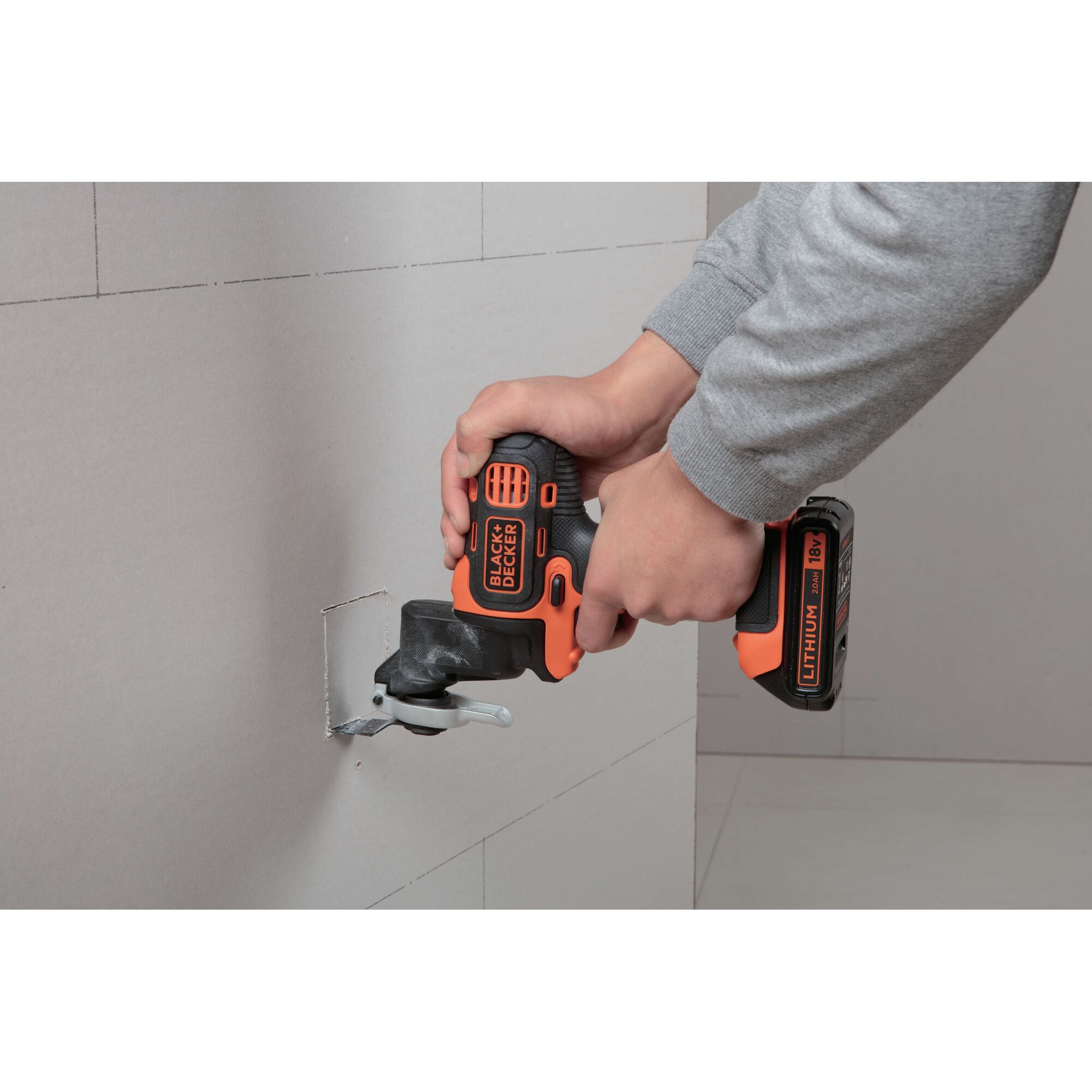 BLACKDECKER EOH183 cordless multi-tool cutting drywall, close-up of tool in use.