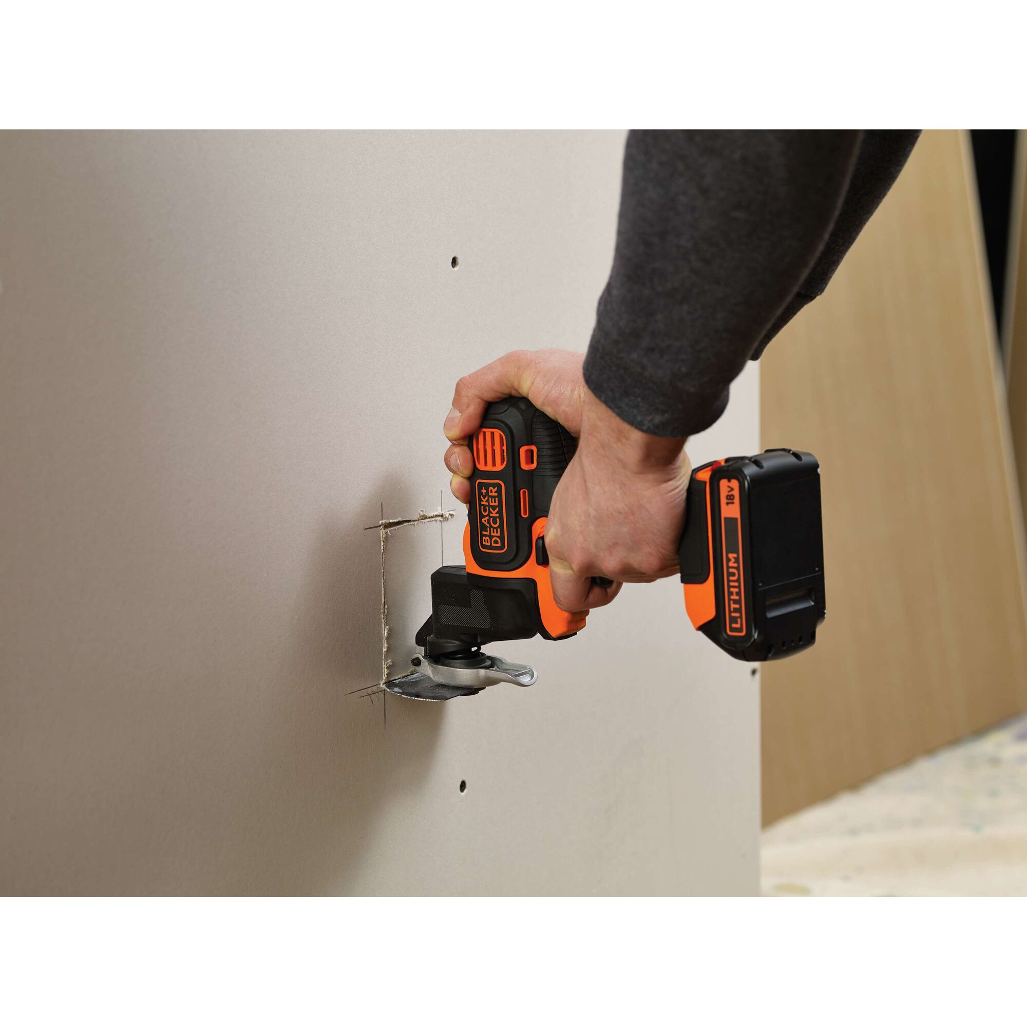 BLACKDECKER EOH183 cordless oscillating tool cutting drywall, close-up view.