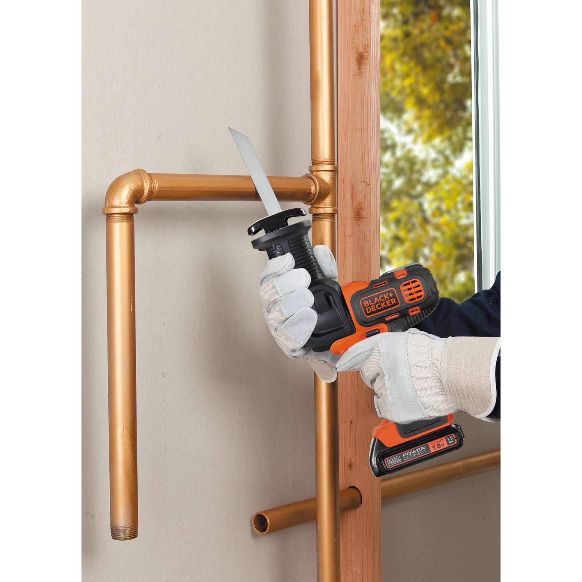 BLACKDECKER EVO183C1 cordless reciprocating saw cutting copper pipes, shown in use.