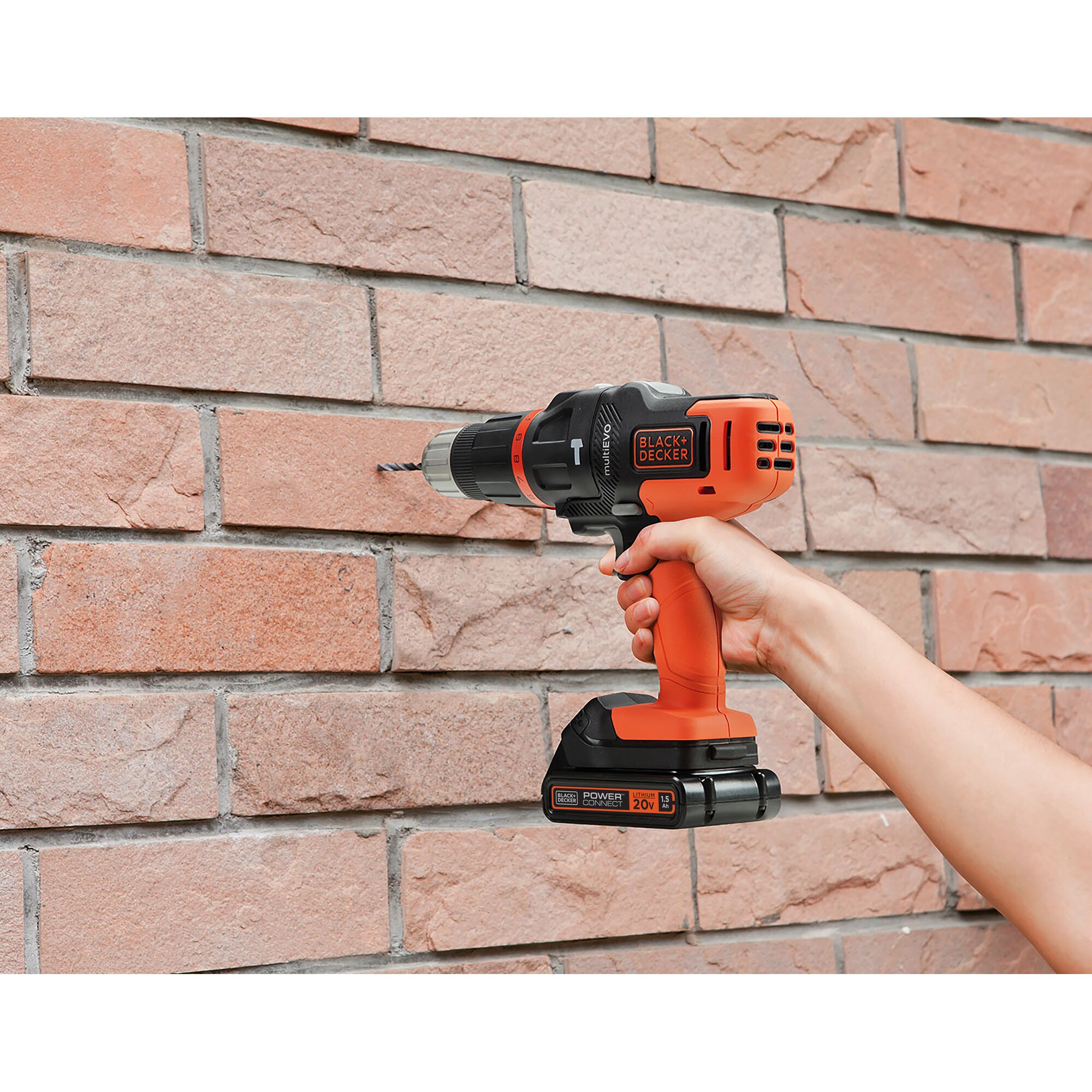 BLACKDECKER EVO185B1 cordless drill used on brick wall, close-up photo of power tool in operation.