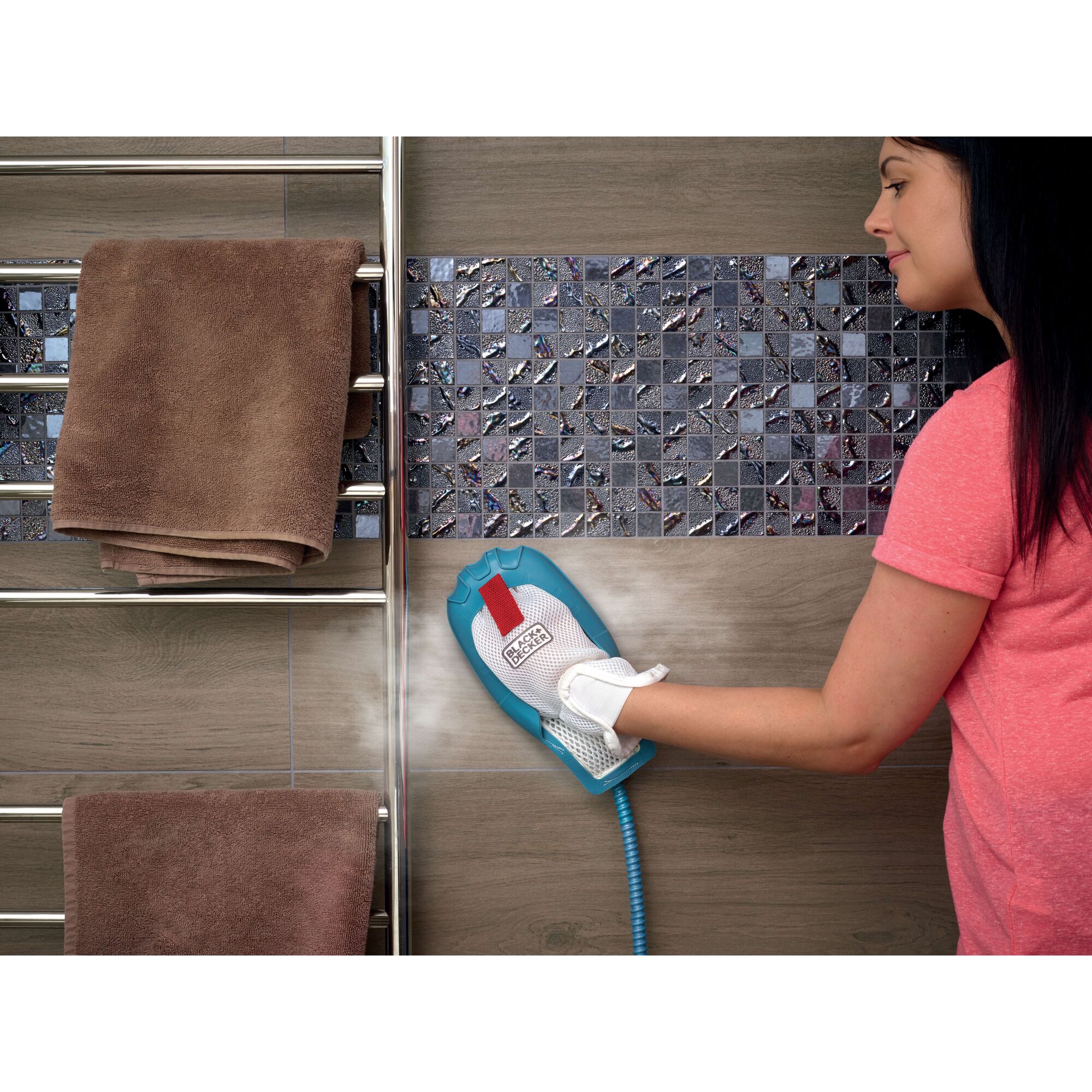 BLACKDECKER FSH10SM steam cleaning glove in use on tiled wall, next to towel rack, side angle.