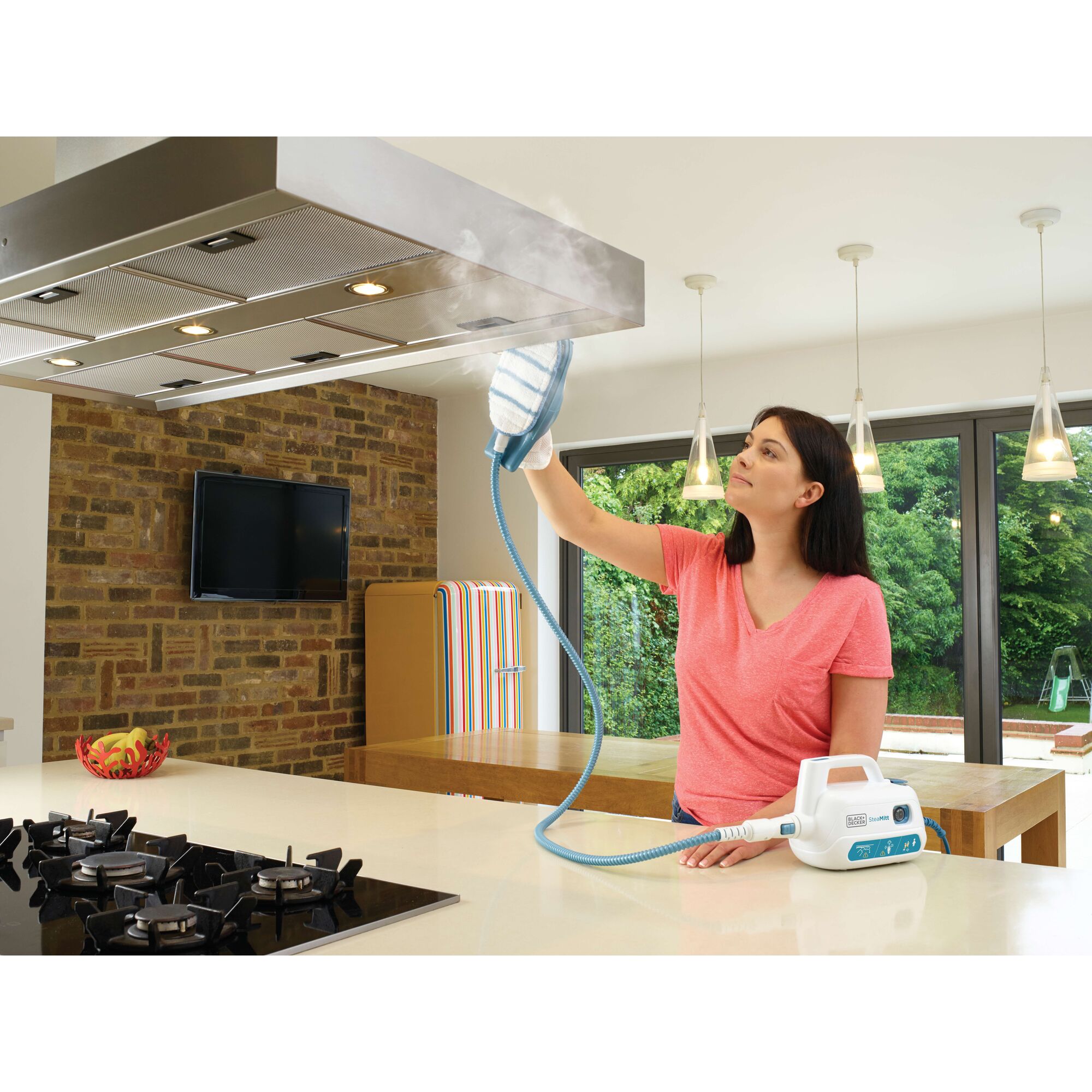 BLACKDECKER FSH10SM steam cleaner used on kitchen range hood by person in bright modern kitchen.
