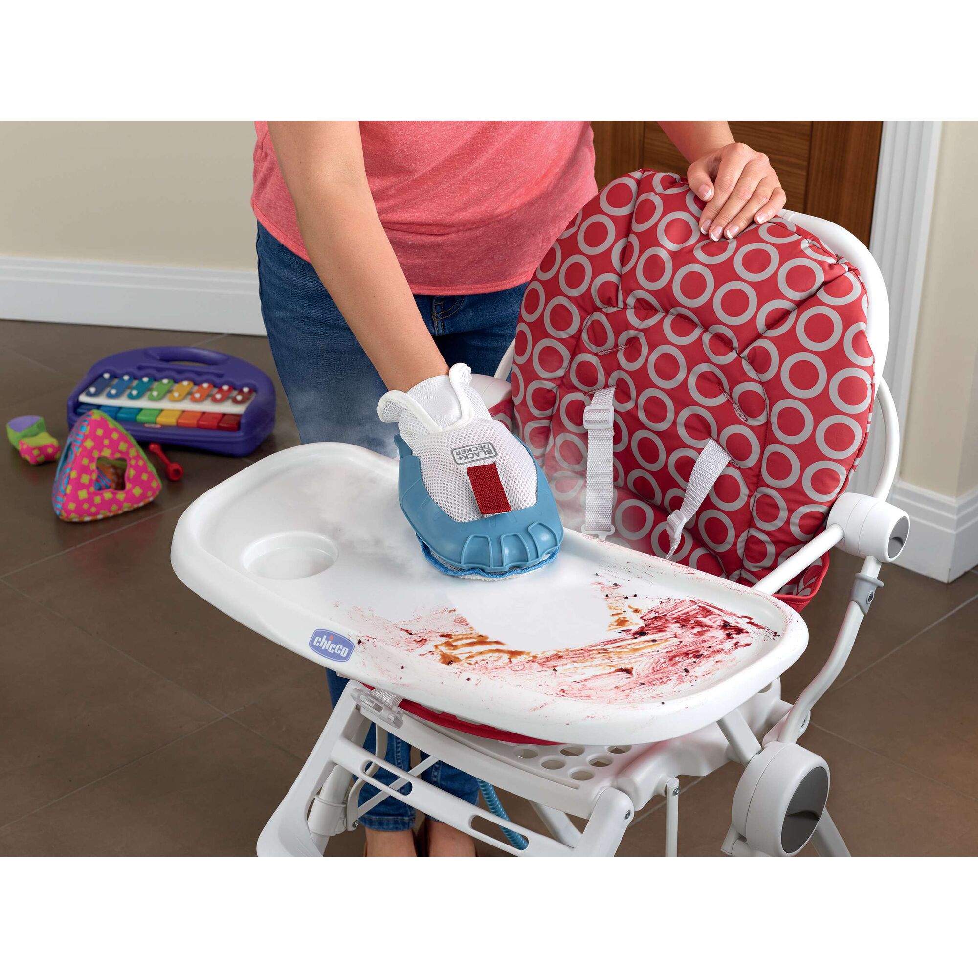 BLACKDECKER FSH10SM handheld steamer cleaning a stained high chair tray, shown from above on white background