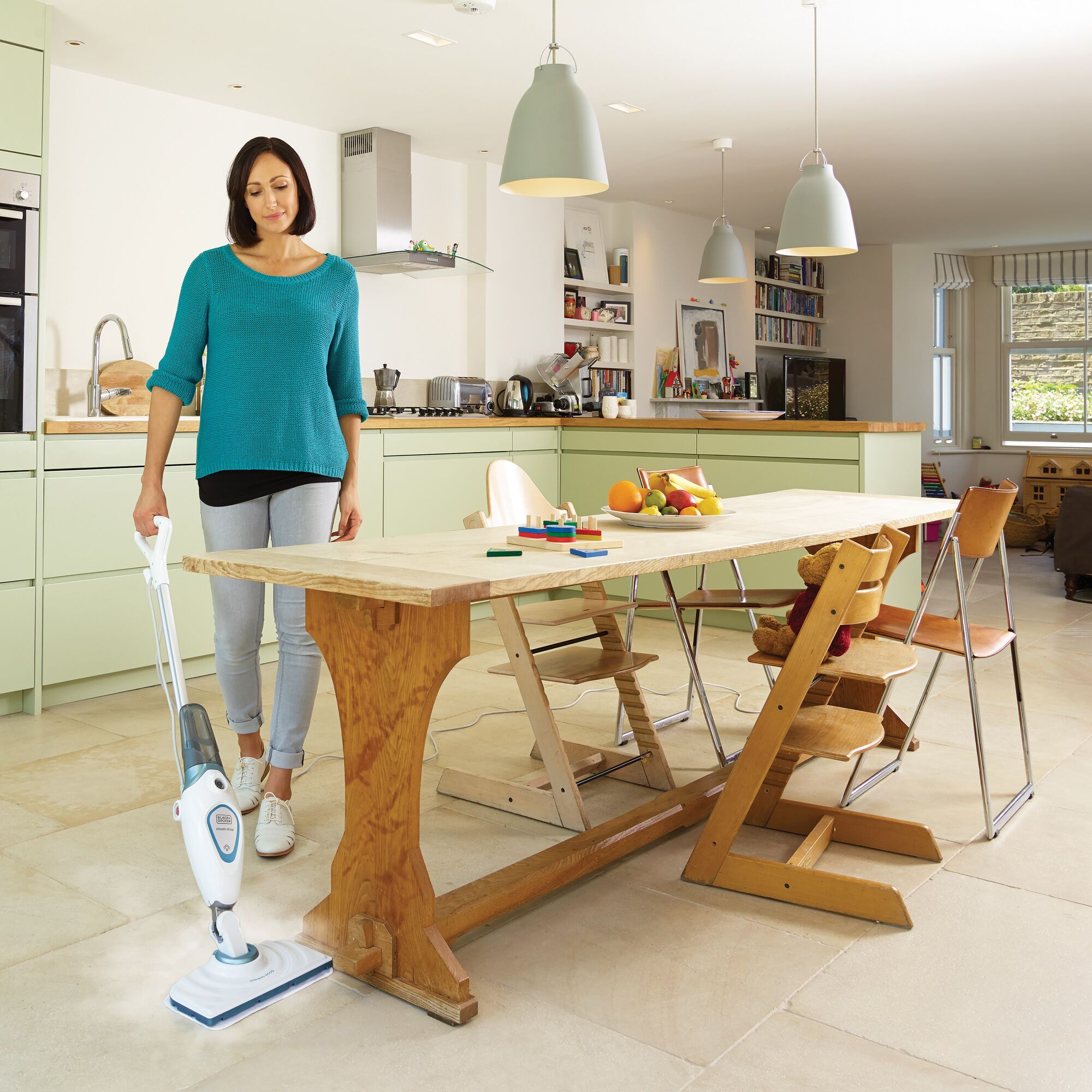 Photo of BLACKDECKER FSM1605 steam mop in use on a kitchen floor near a wooden dining table.