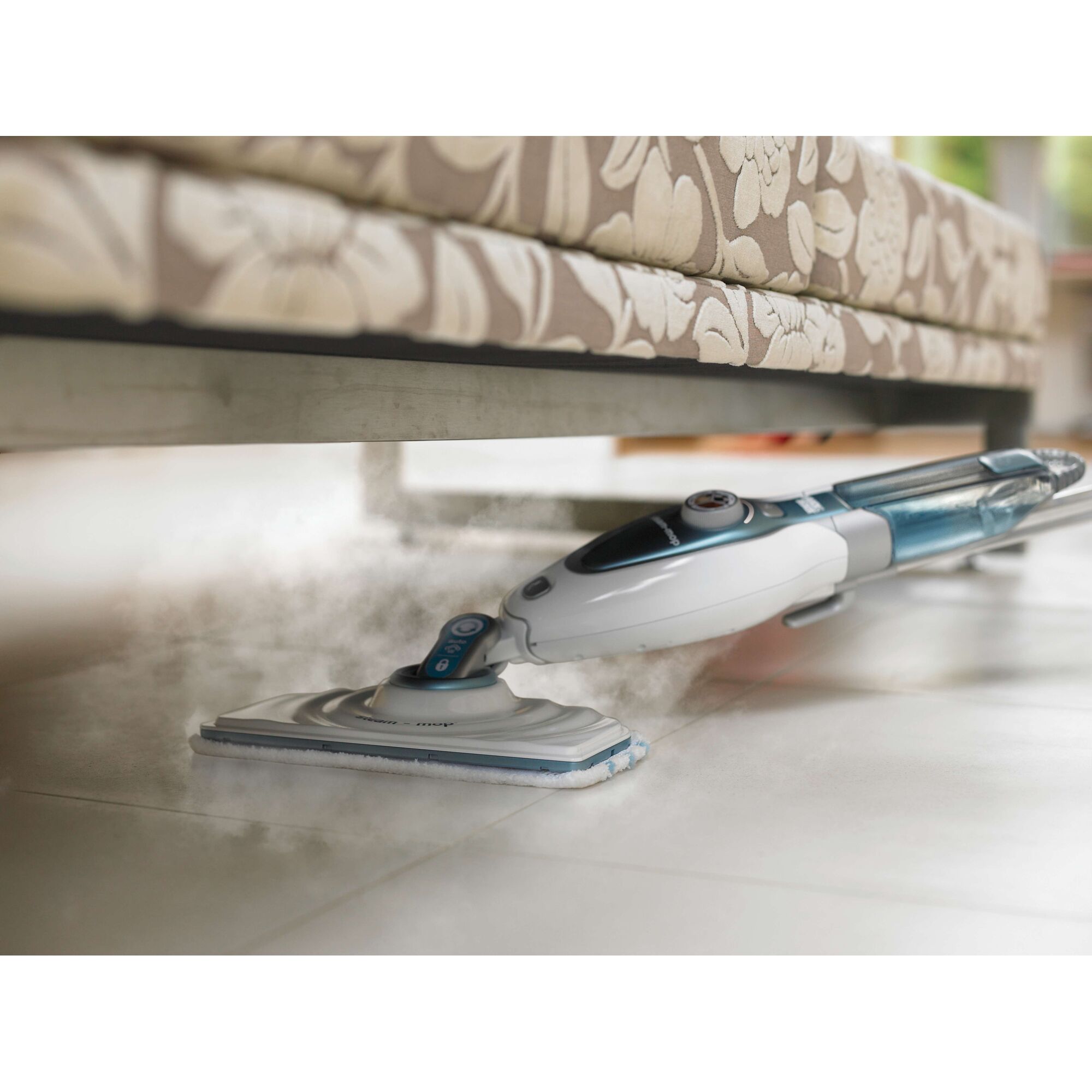 BLACKDECKER FSM1620 steam mop cleaning tile floor under patterned sofa, photography side angle.