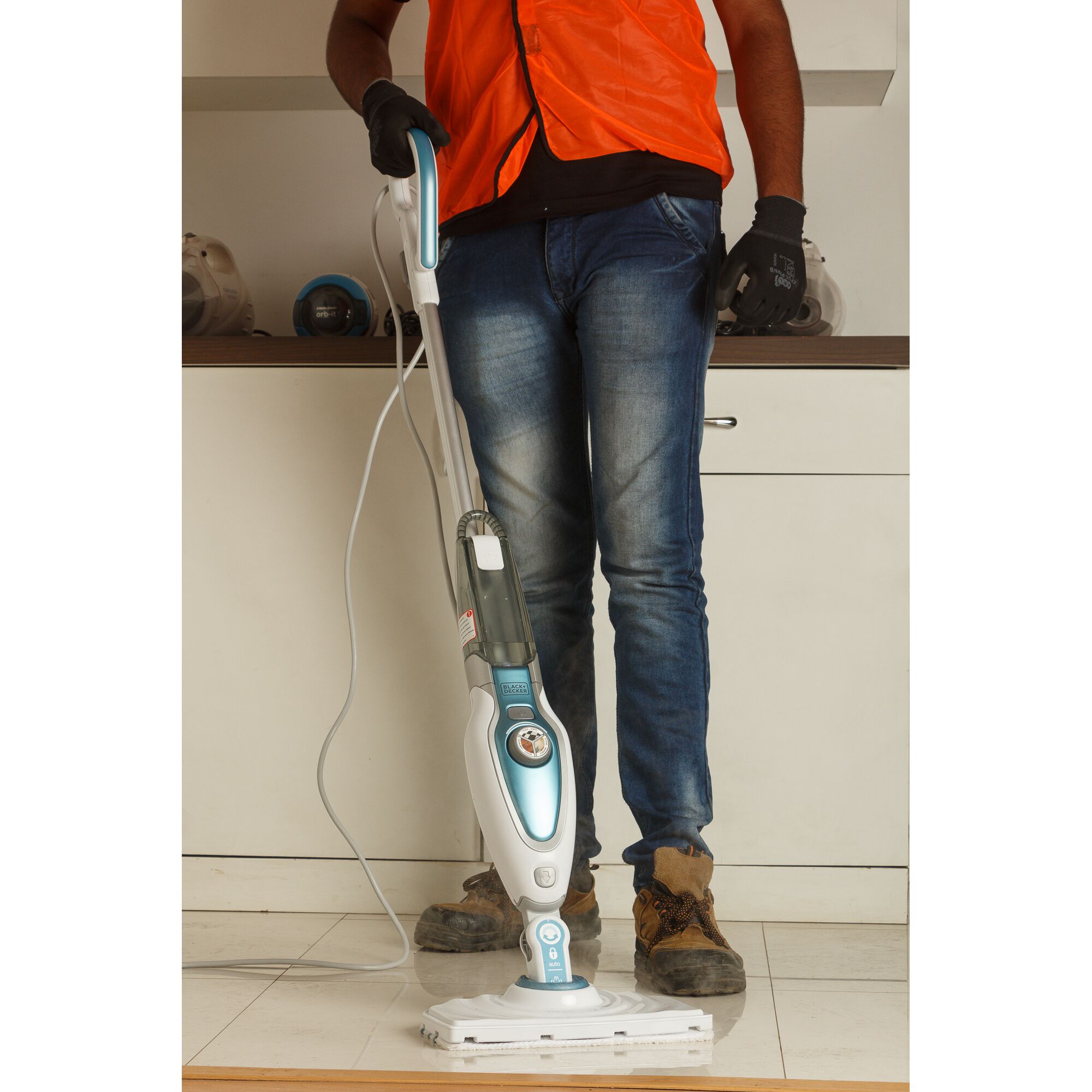 BLACKDECKER FSM1620 steam mop held upright by person on indoor tile floor, cleaning product photography.