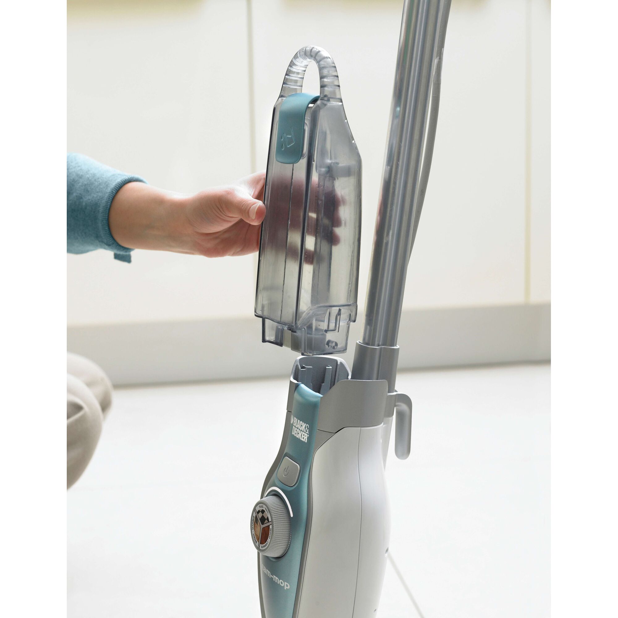 BLACKDECKER FSM1620 steam mop with detachable water tank being removed by hand.