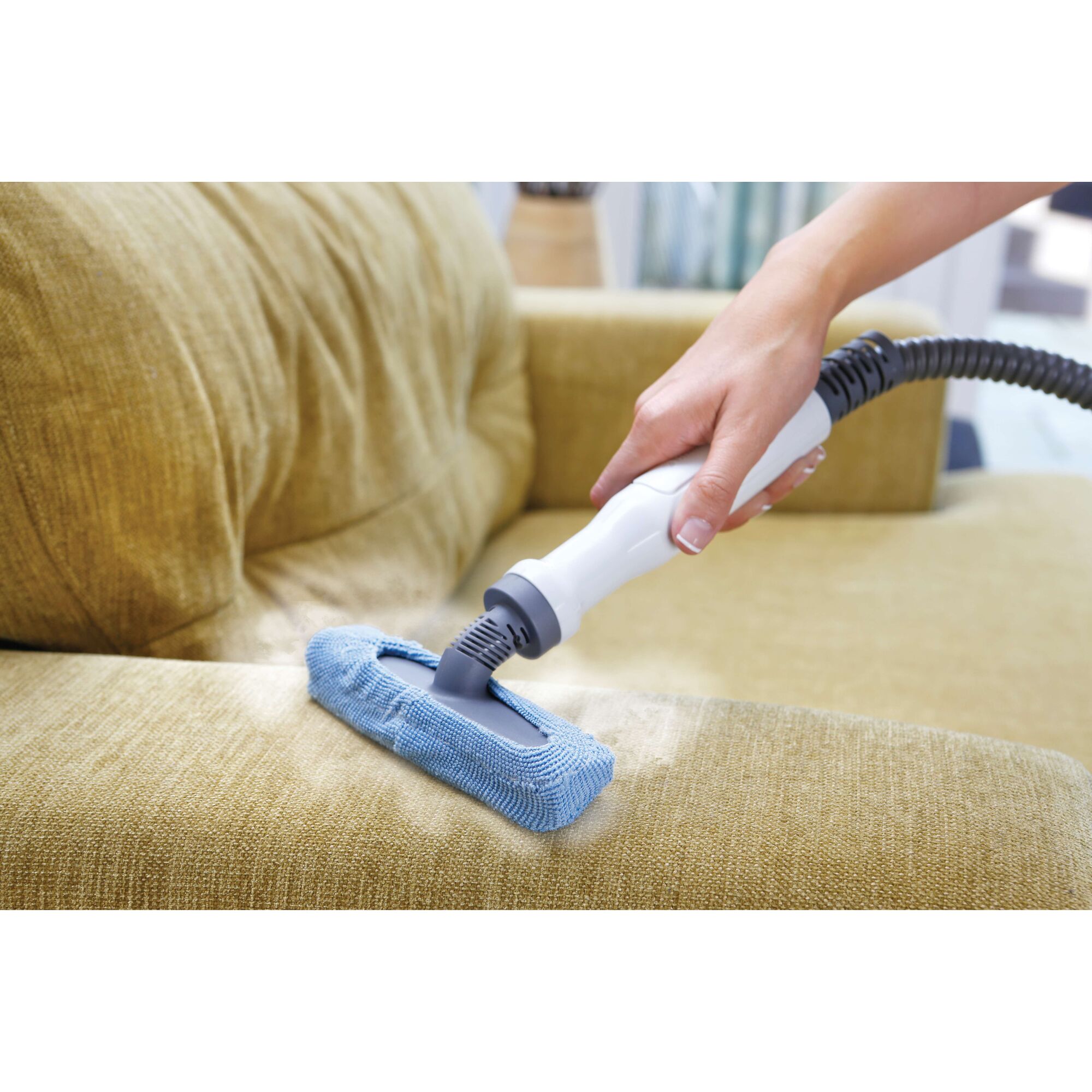 BLACKDECKER FSMH1300FX handheld steam cleaner used on yellow sofa upholstery