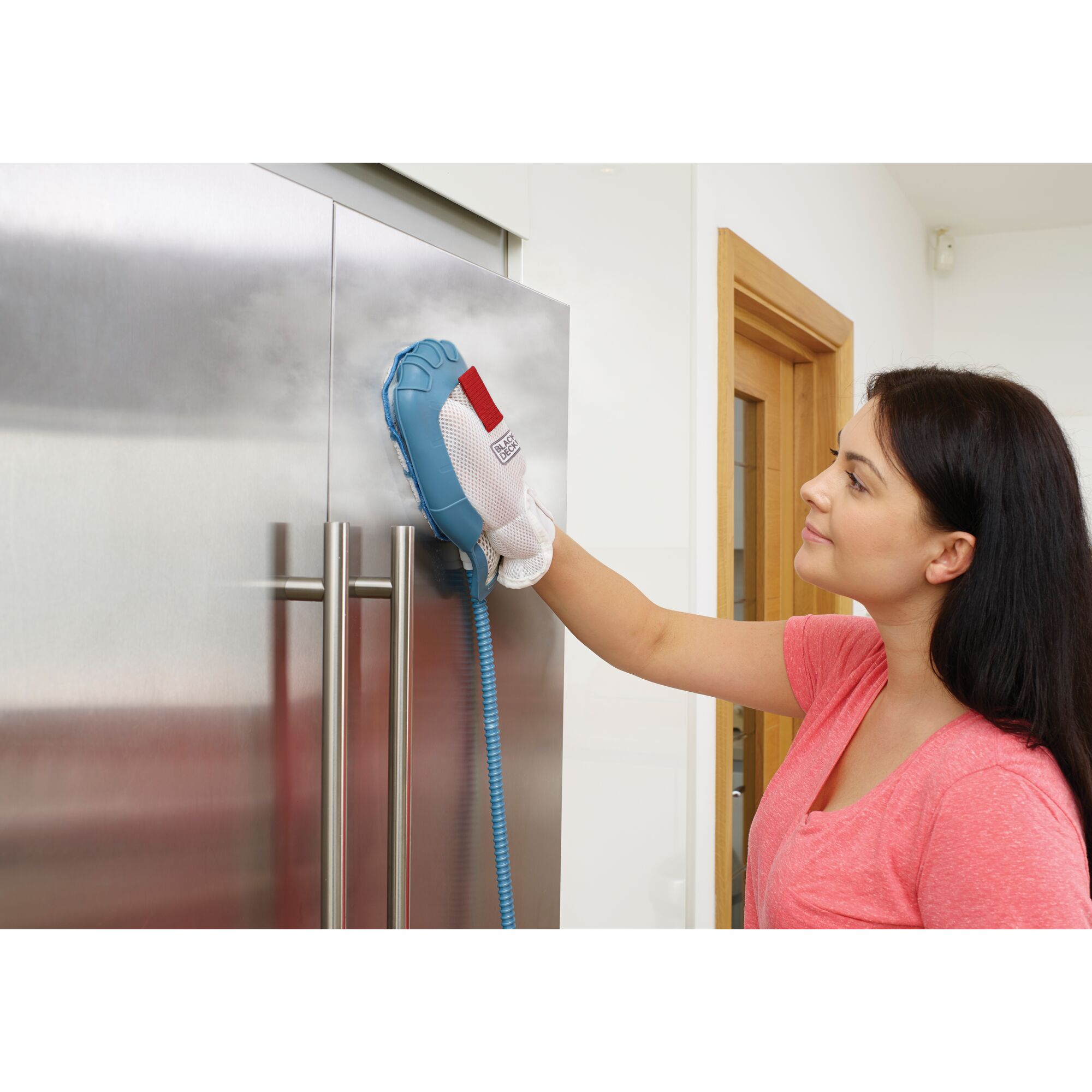 BLACK+DECKER FSMH13151SM steam cleaning mitt in use, cleaning stainless steel fridge door in modern kitchen.