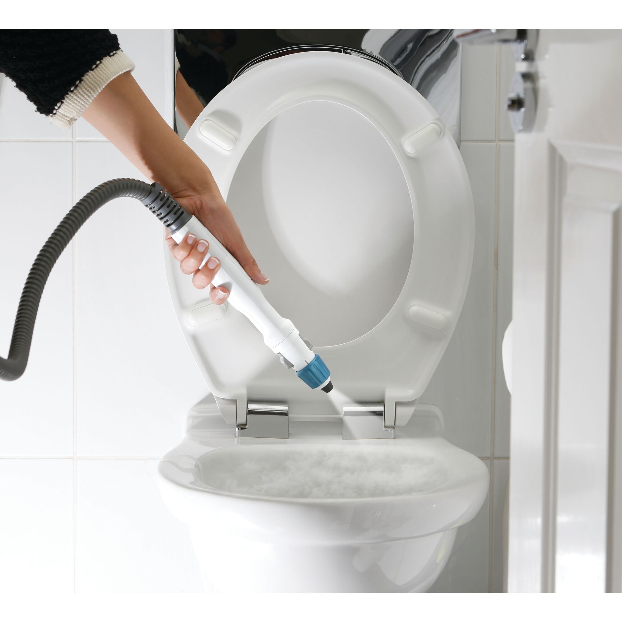 A person is using a steam cleaning device to sanitize the inside of a toilet bowl. The steam cleaner has a white and blue nozzle, and the toilet is white with the lid open.