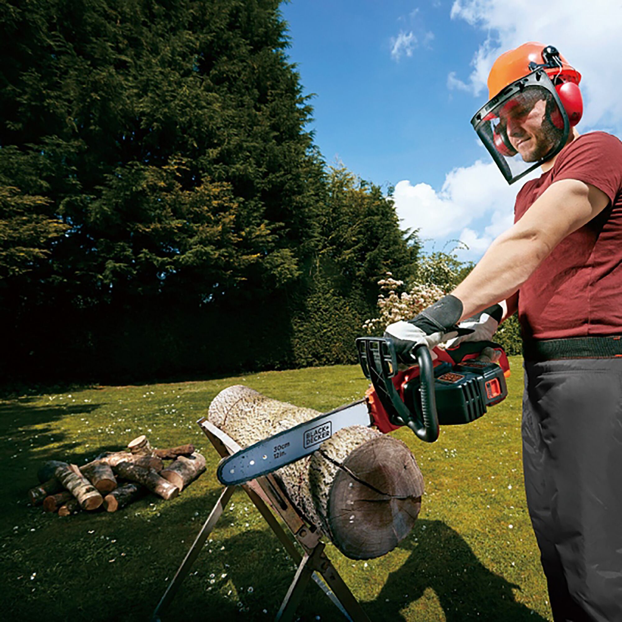 BLACKDECKER GKC3630L cordless chainsaw cutting wood outdoors, person wearing safety gear.