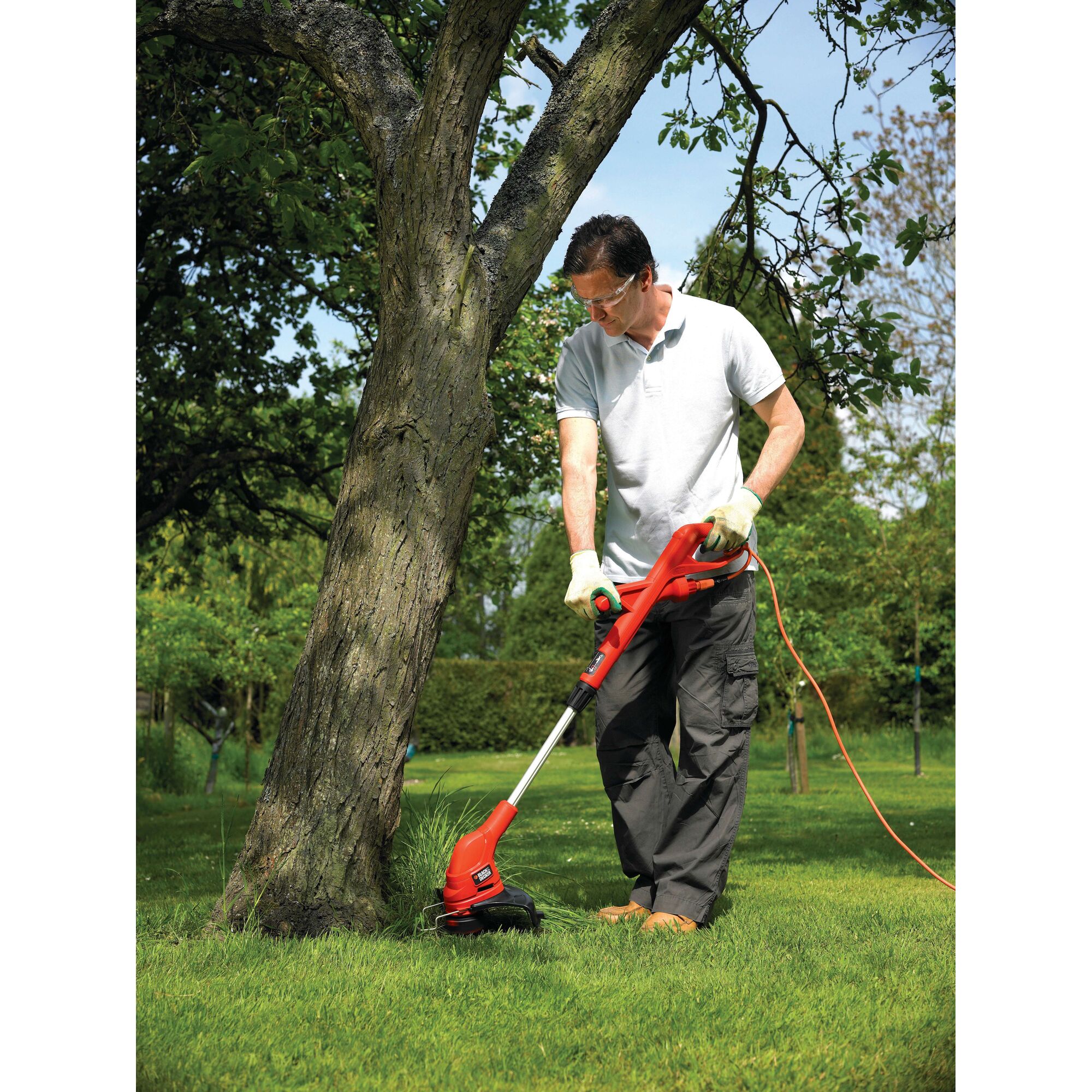 BLACKDECKER GL4525 grass trimmer in use outdoors on lawn near tree