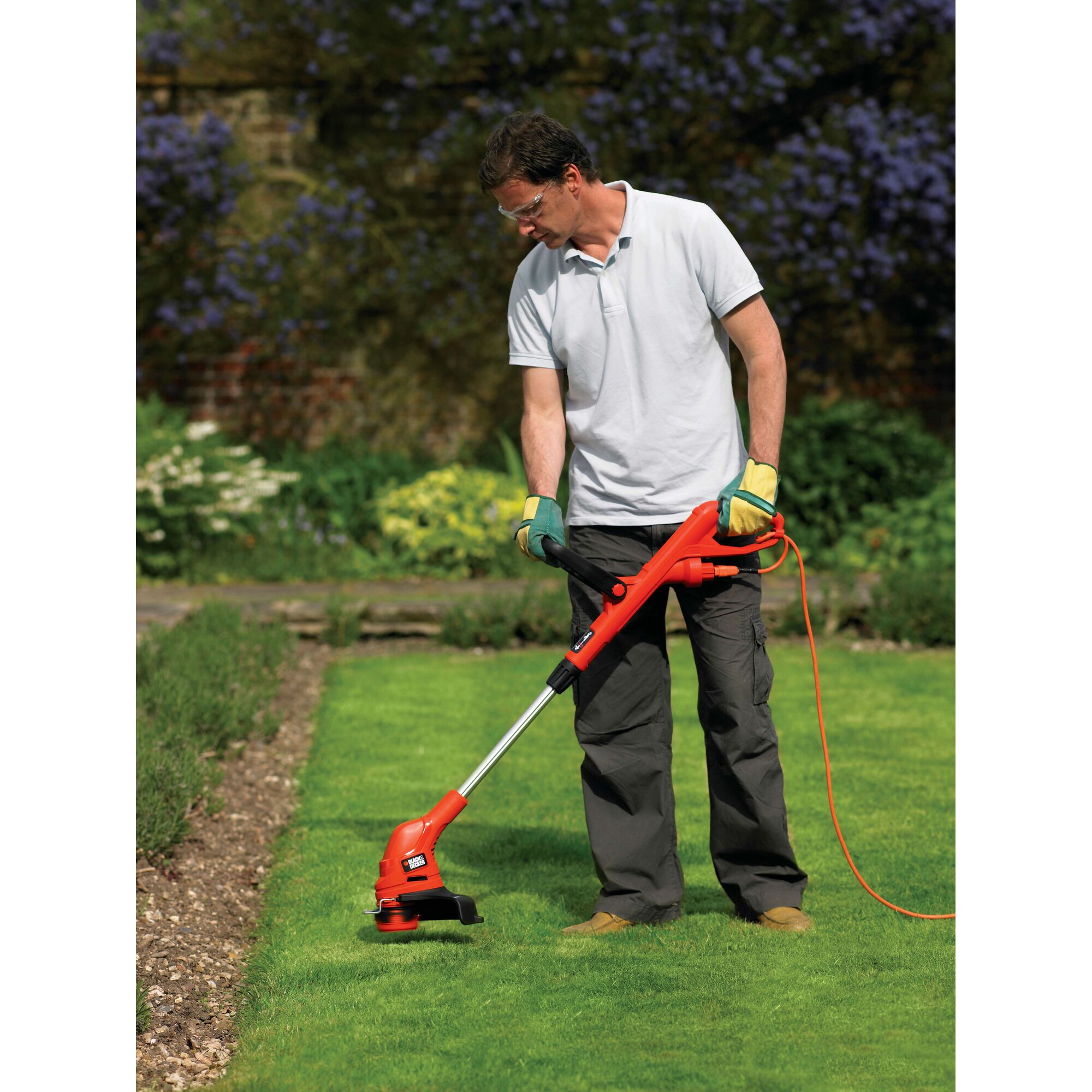 BLACKDECKER GL5530 grass trimmer in use on a lawn, bright orange design, outdoor garden setting