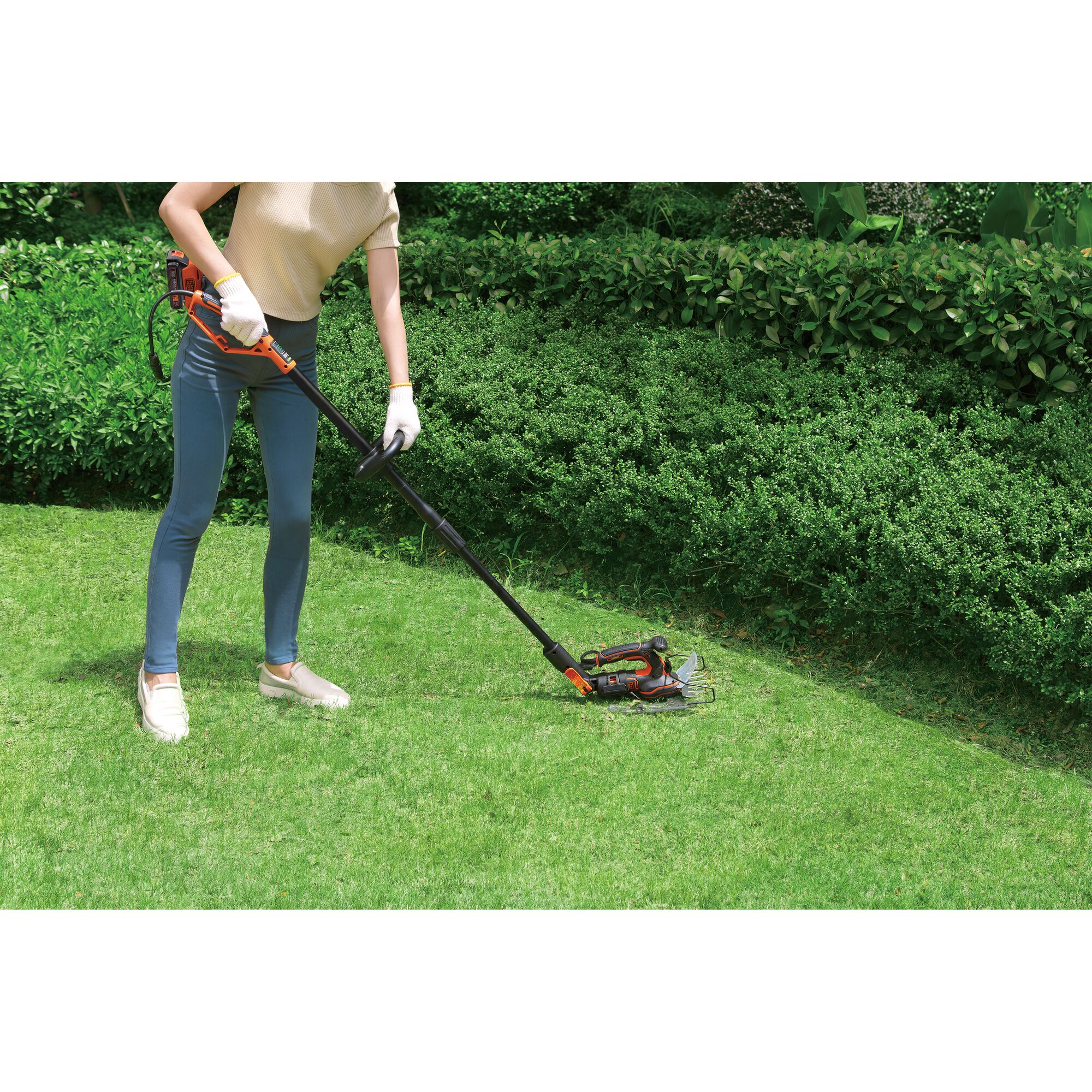 BLACKDECKER GPSH1820 grass trimmer in use, person cutting lawn near hedge, outdoor garden scene.