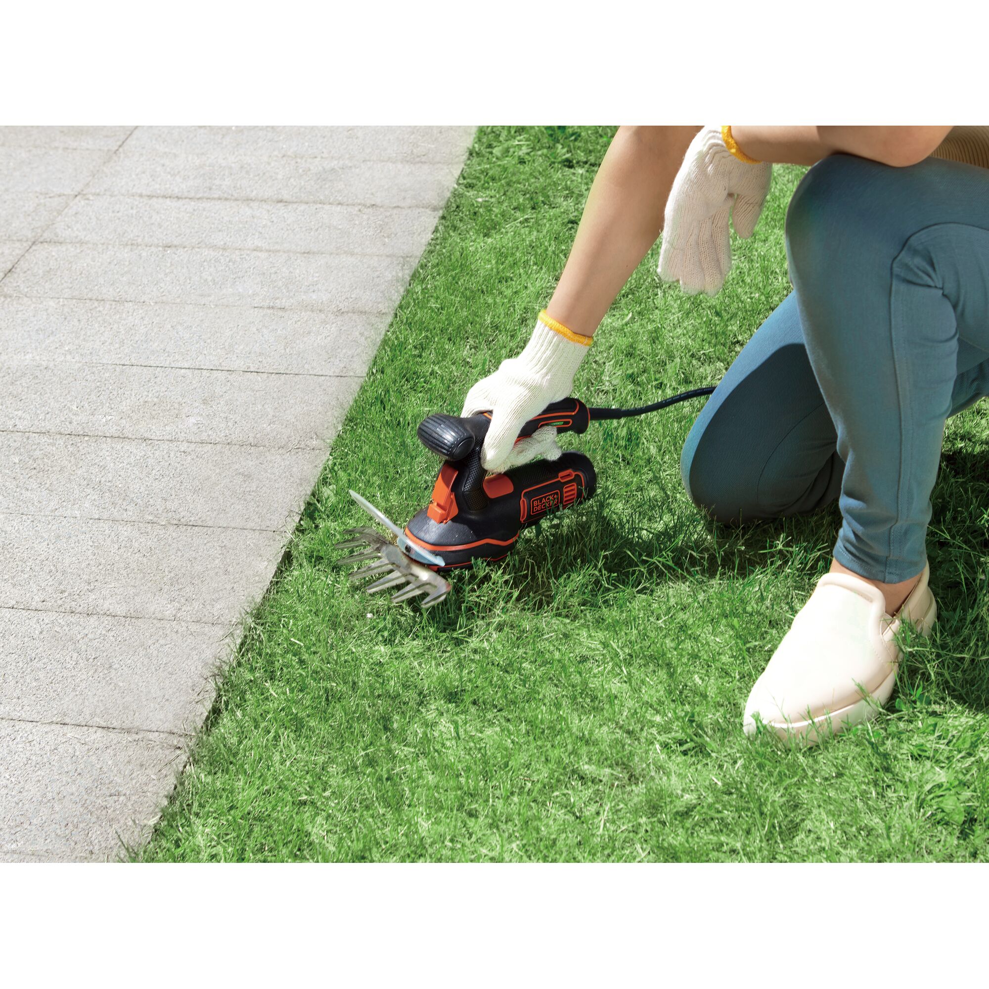 BLACK+DECKER GPSH1820 grass shear tool used trimming lawn edge near pavement.