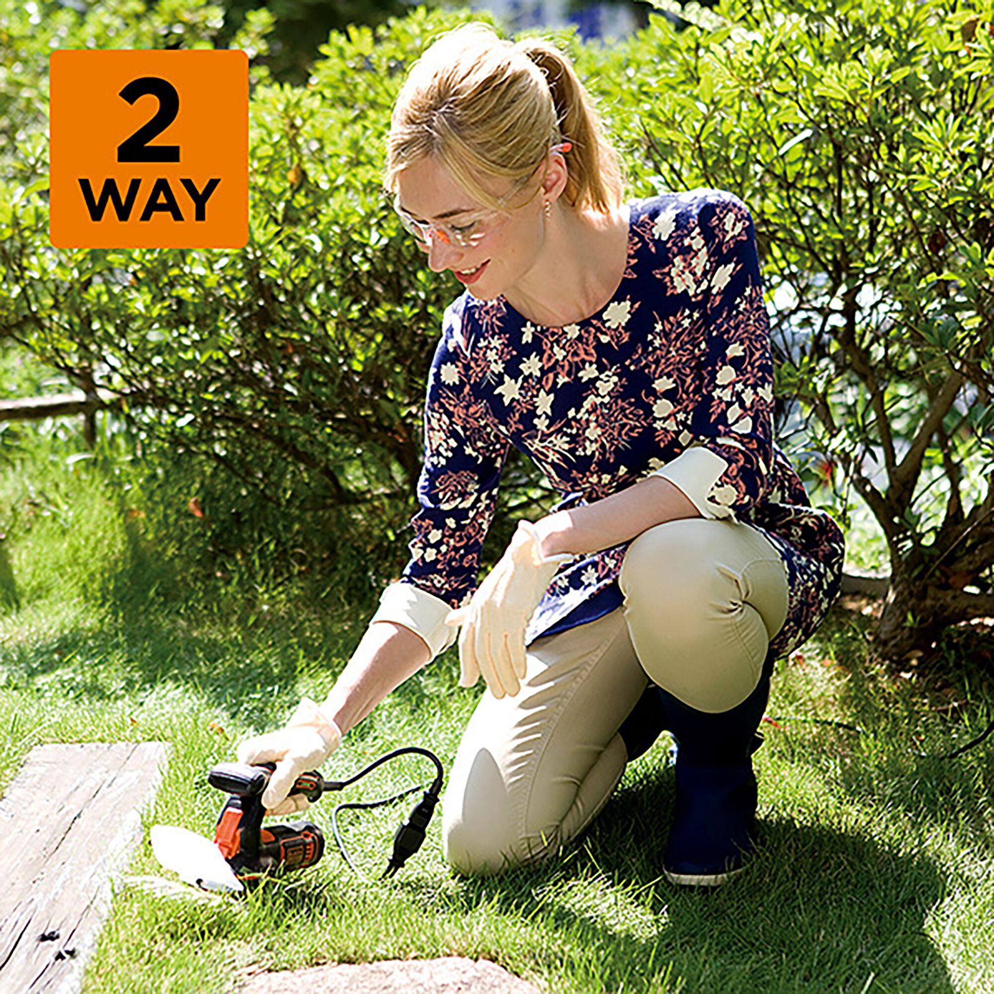 BLACKDECKER GSH1000 garden tool used outdoors by person wearing gloves, kneeling on grass.
