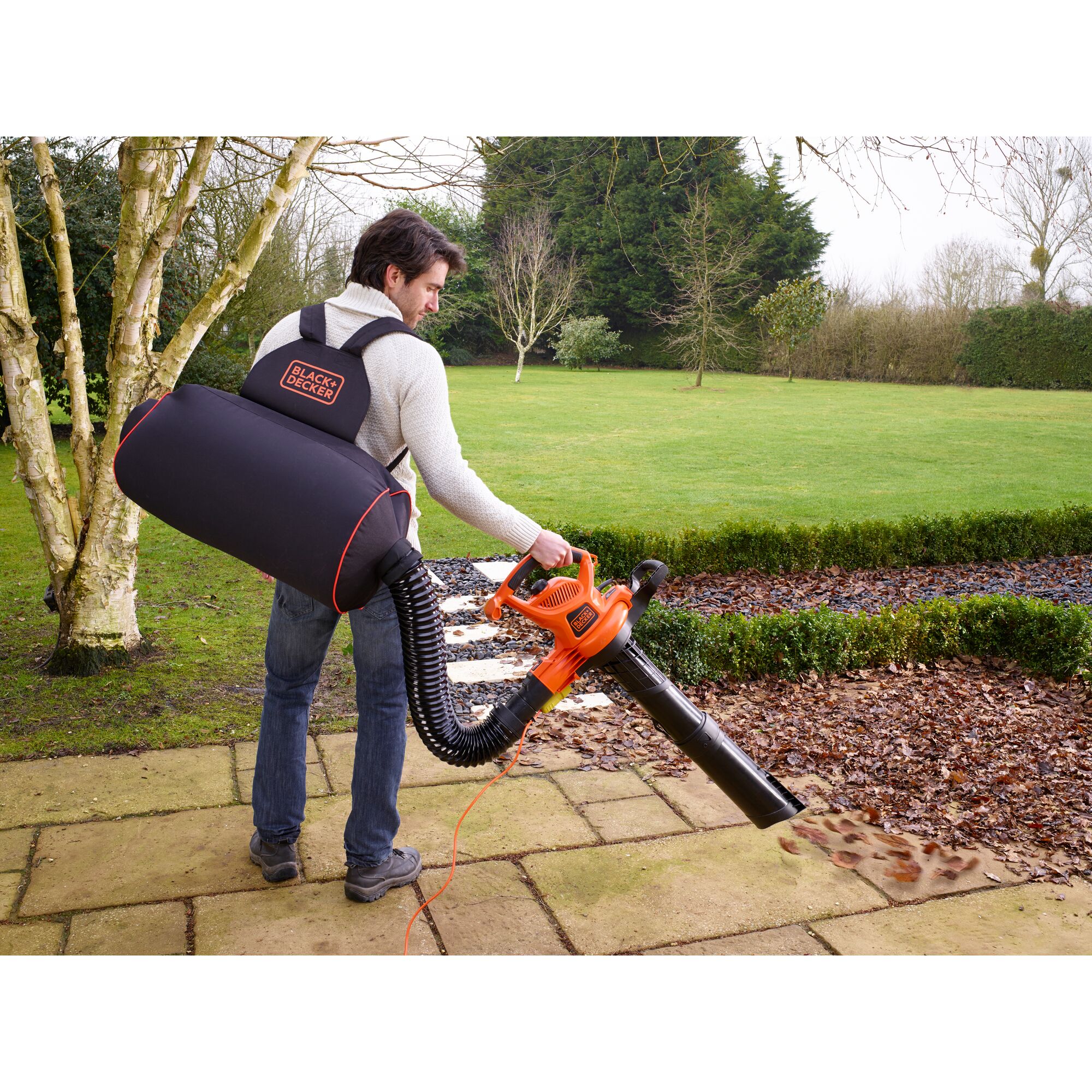 Photo of BLACKDECKER GW3031BP leaf blower and vacuum with backpack collection bag in outdoor garden setting.
