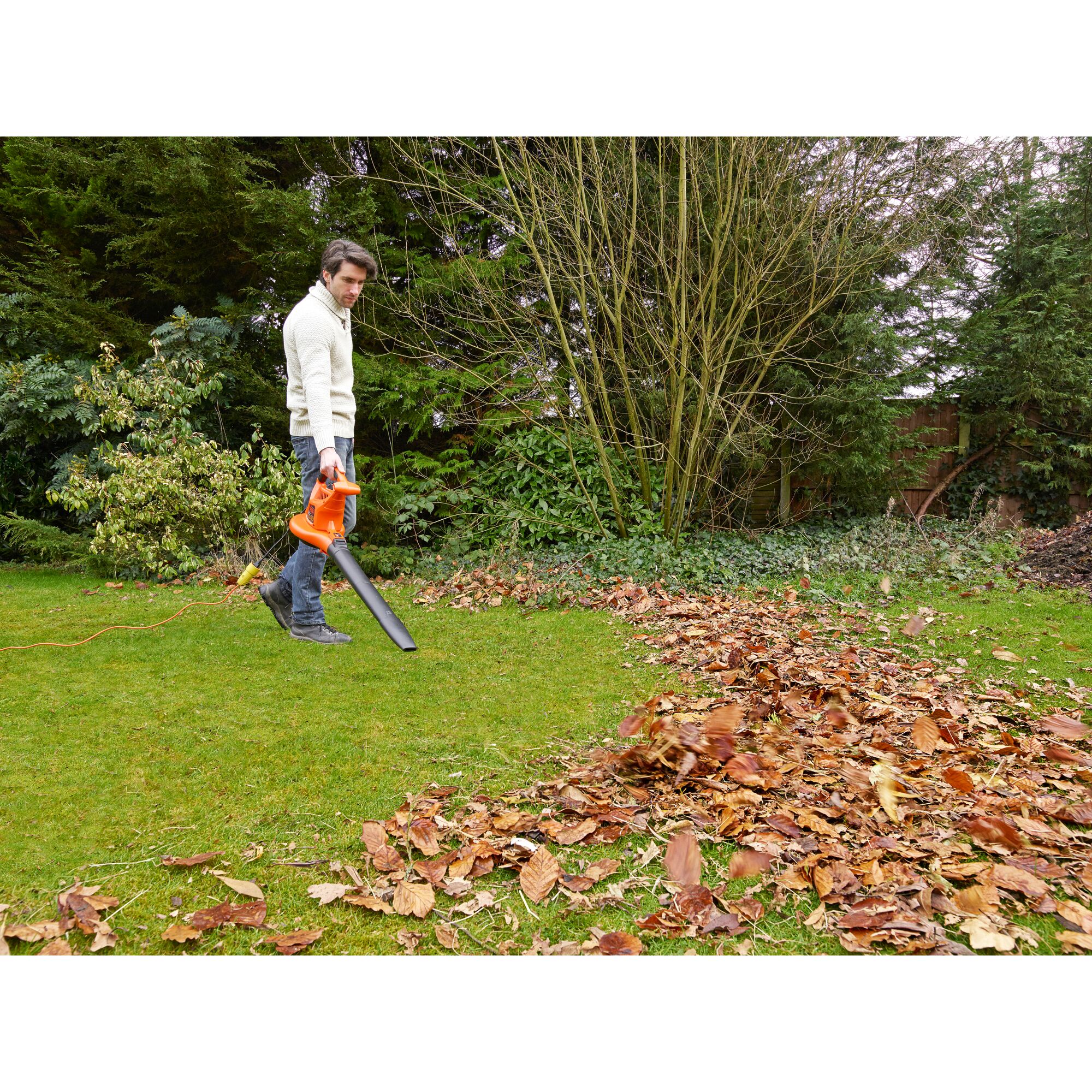 Photo of BLACKDECKER GW3031BP leaf blower used outdoors to clear fallen leaves on grass.