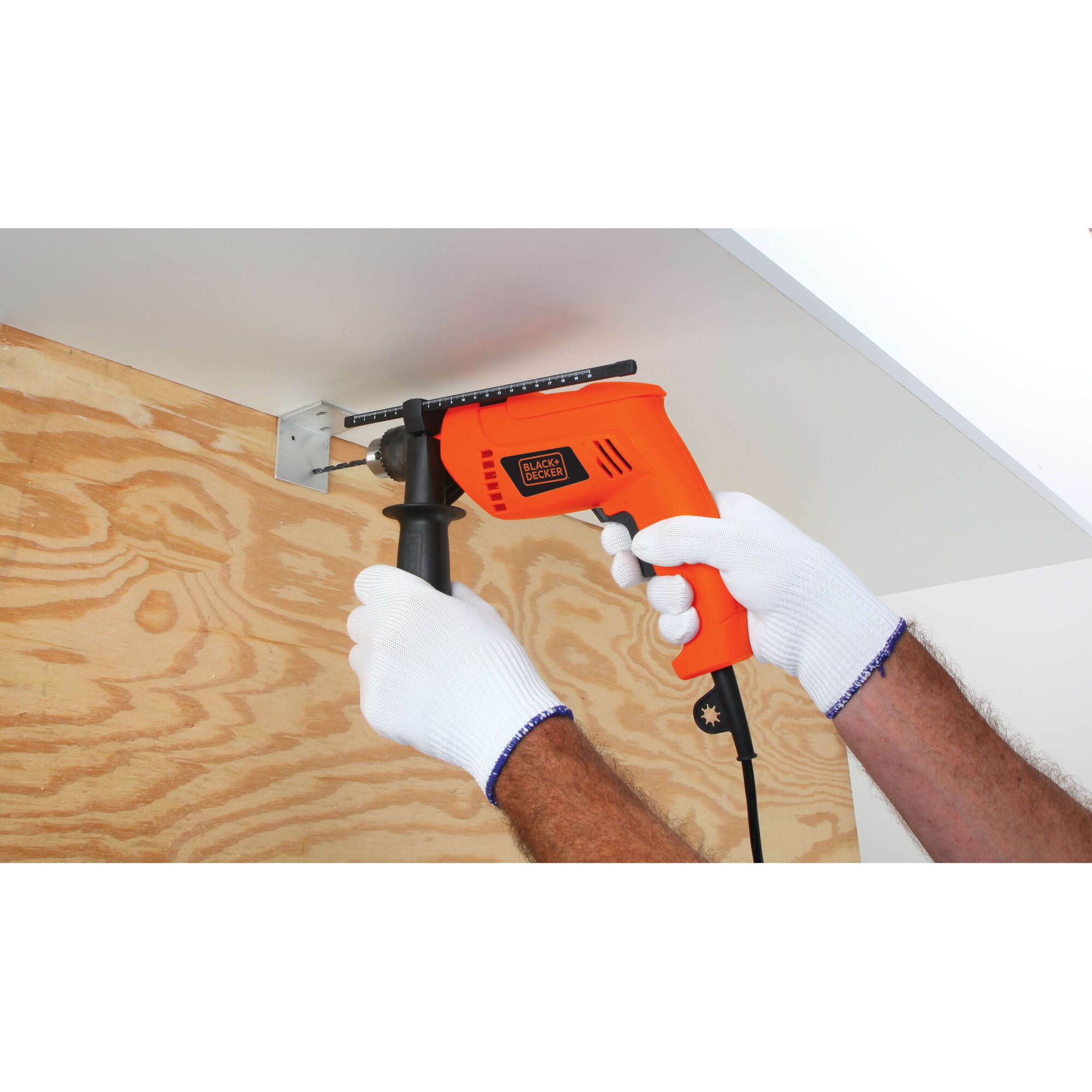 BLACKDECKER HD650 orange corded drill in use on wood with auxiliary handle, close-up photography.