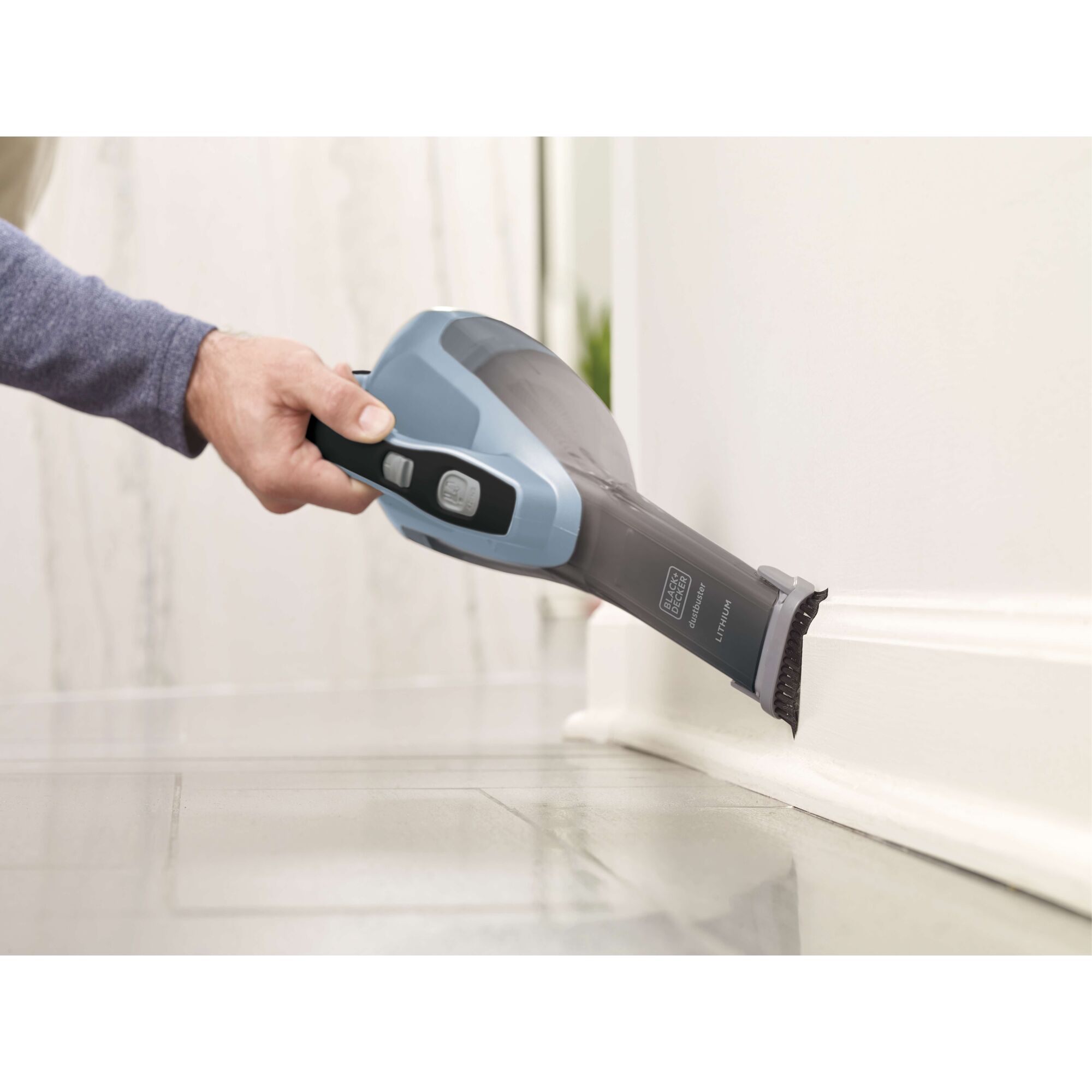 Photo of BLACKDECKER HLVA315J32 handheld vacuum cleaning baseboard edge.