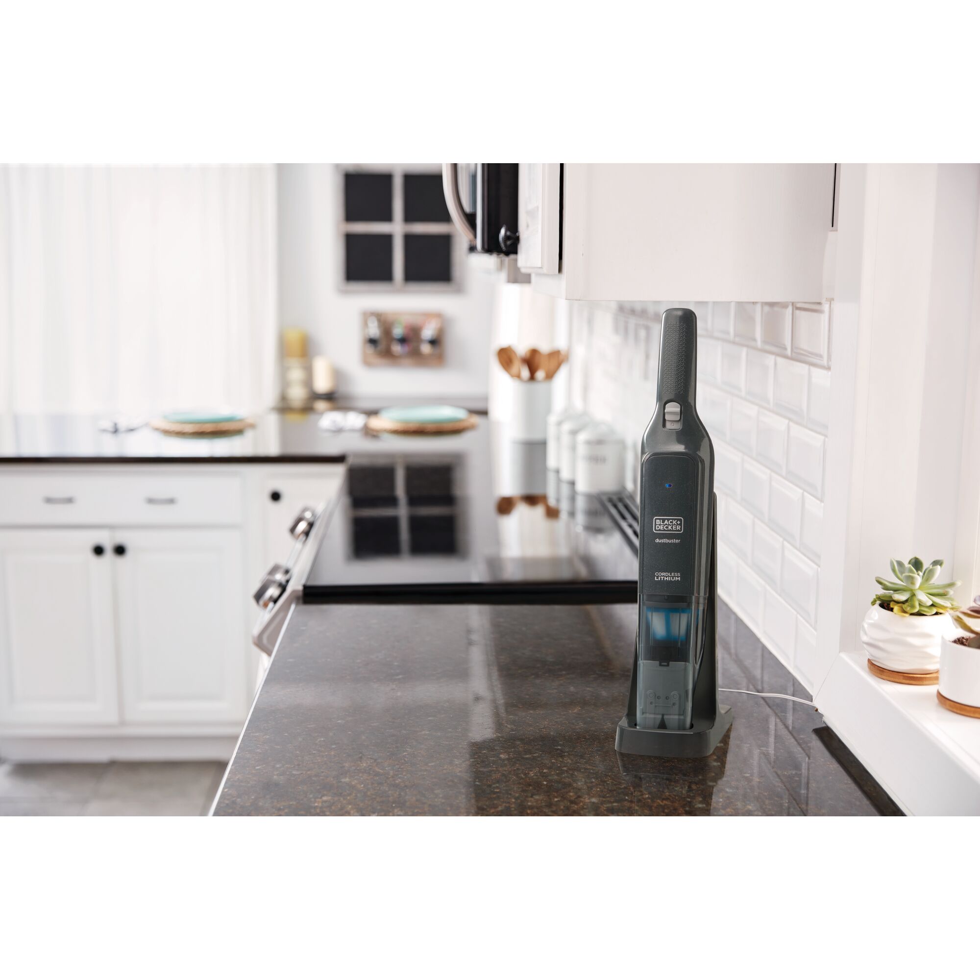 BLACK+DECKER HLVC320B handheld vacuum on brown kitchen counter with charging base, near white cabinets.